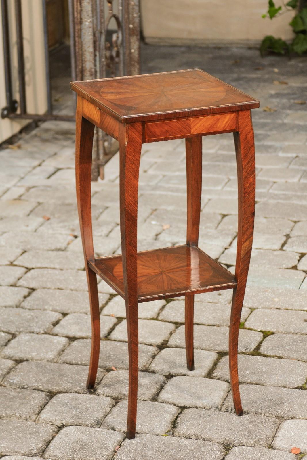 An Italian walnut veneered side table from the early 19th century, with geometrical inlay and pull-out shelf. Born in Italy during the early years of the 19th century, this exquisite side table features a square top, adorned in its center with a