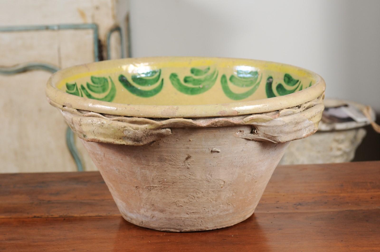 An Italian early 19th century yellow and green glazed pottery bowl from Calabria. Born during the early years of the 19th century in the southwestern region of Italy called Calabria, this charming pottery bowl features a nice conic shape, adorned on