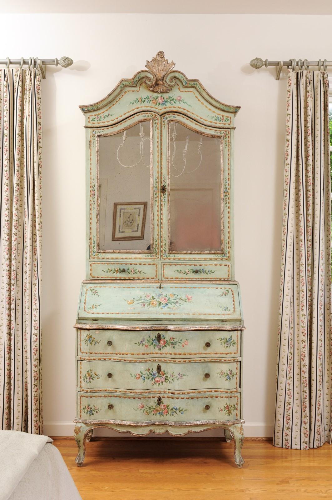An Italian Rococo style two-part secretary from the mid-19th century, with slanted desk, mirrored doors and original paint. How not to fall head over heels in love with this Rococo style Italian tall secretary? Topped with a voluted cornice accented