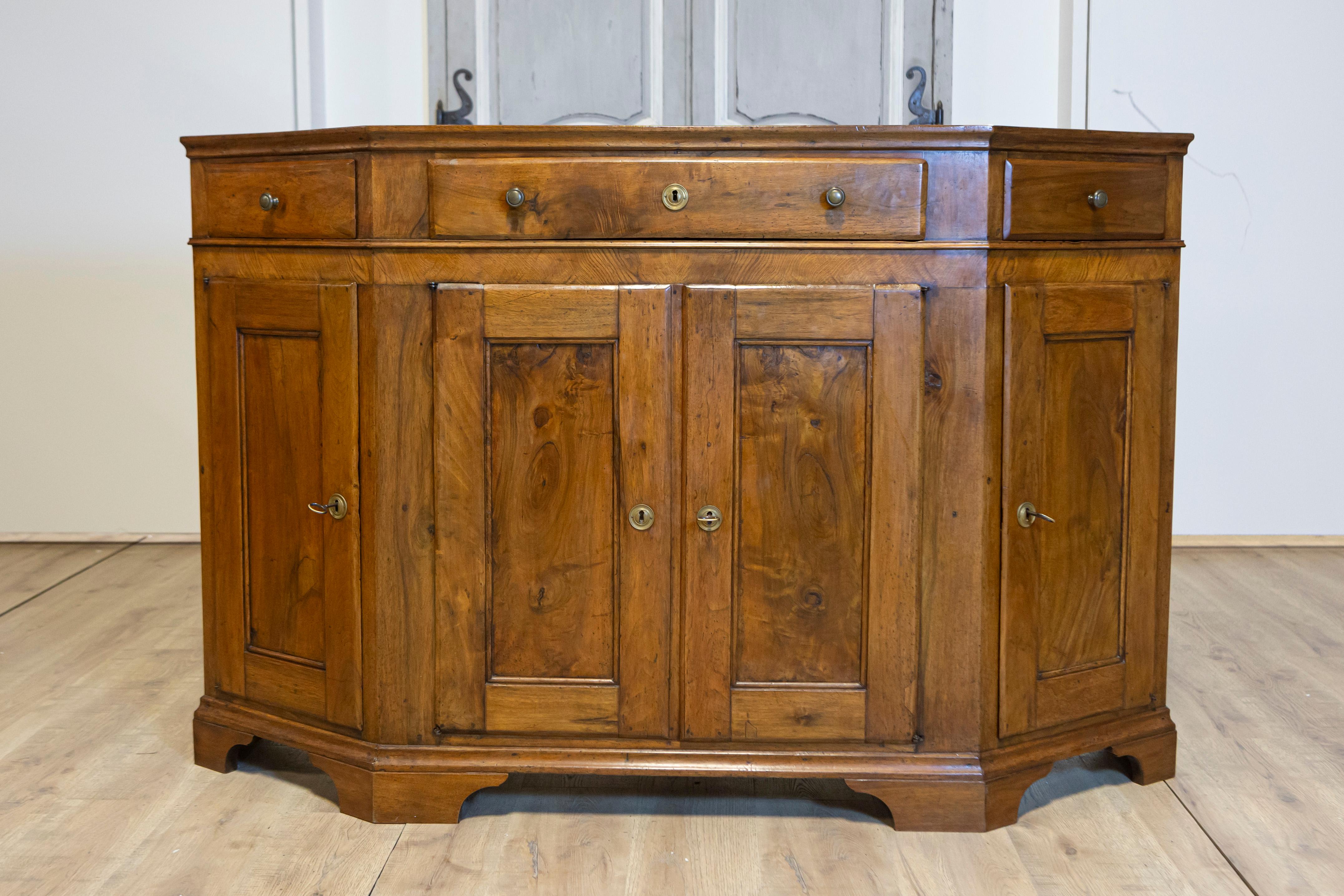 Italienische Nussbaum-Credenza von 1850 mit schrägen Seiten, drei Schubladen über vier Türen (Geschnitzt) im Angebot