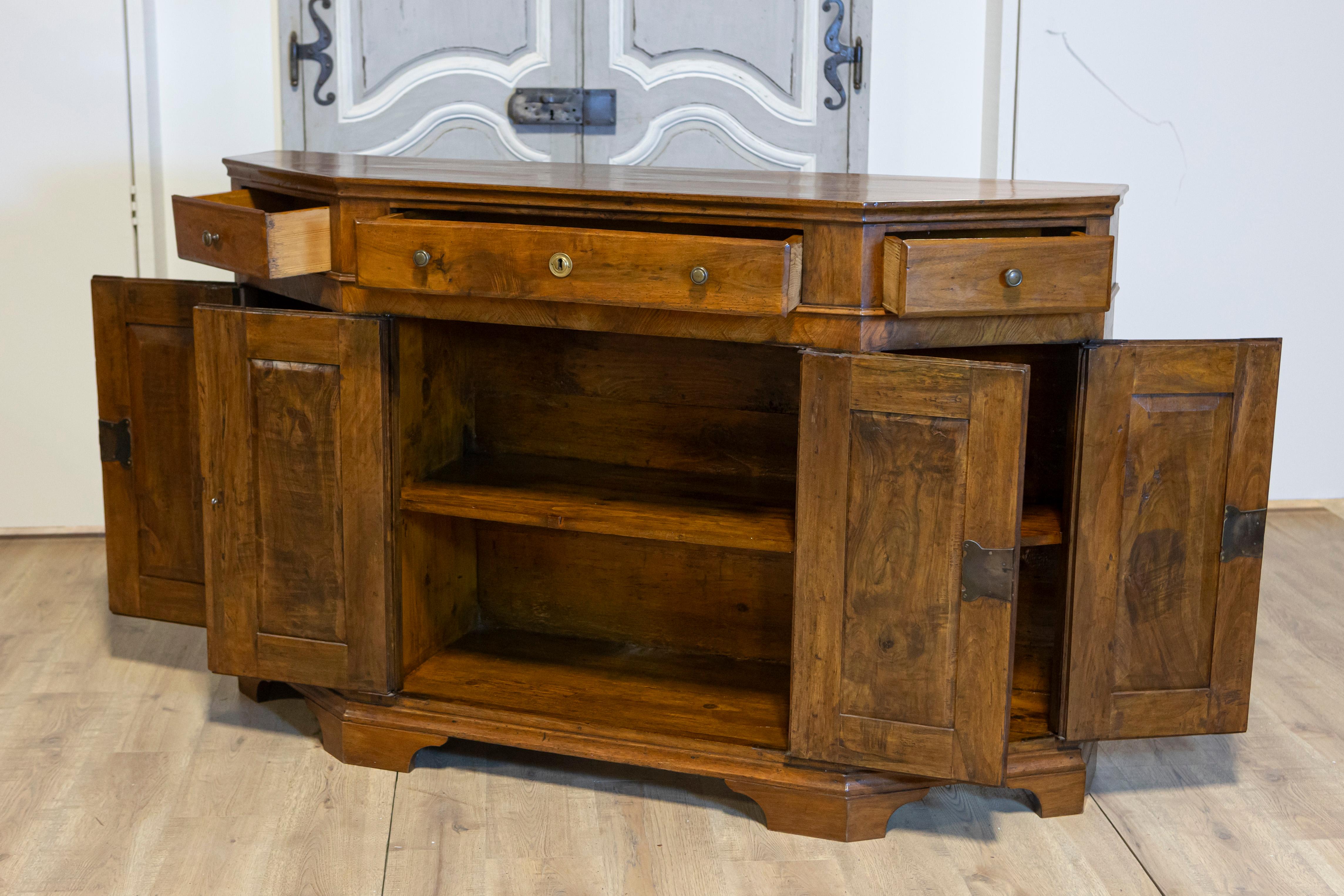 Italienische Nussbaum-Credenza von 1850 mit schrägen Seiten, drei Schubladen über vier Türen (Messing) im Angebot
