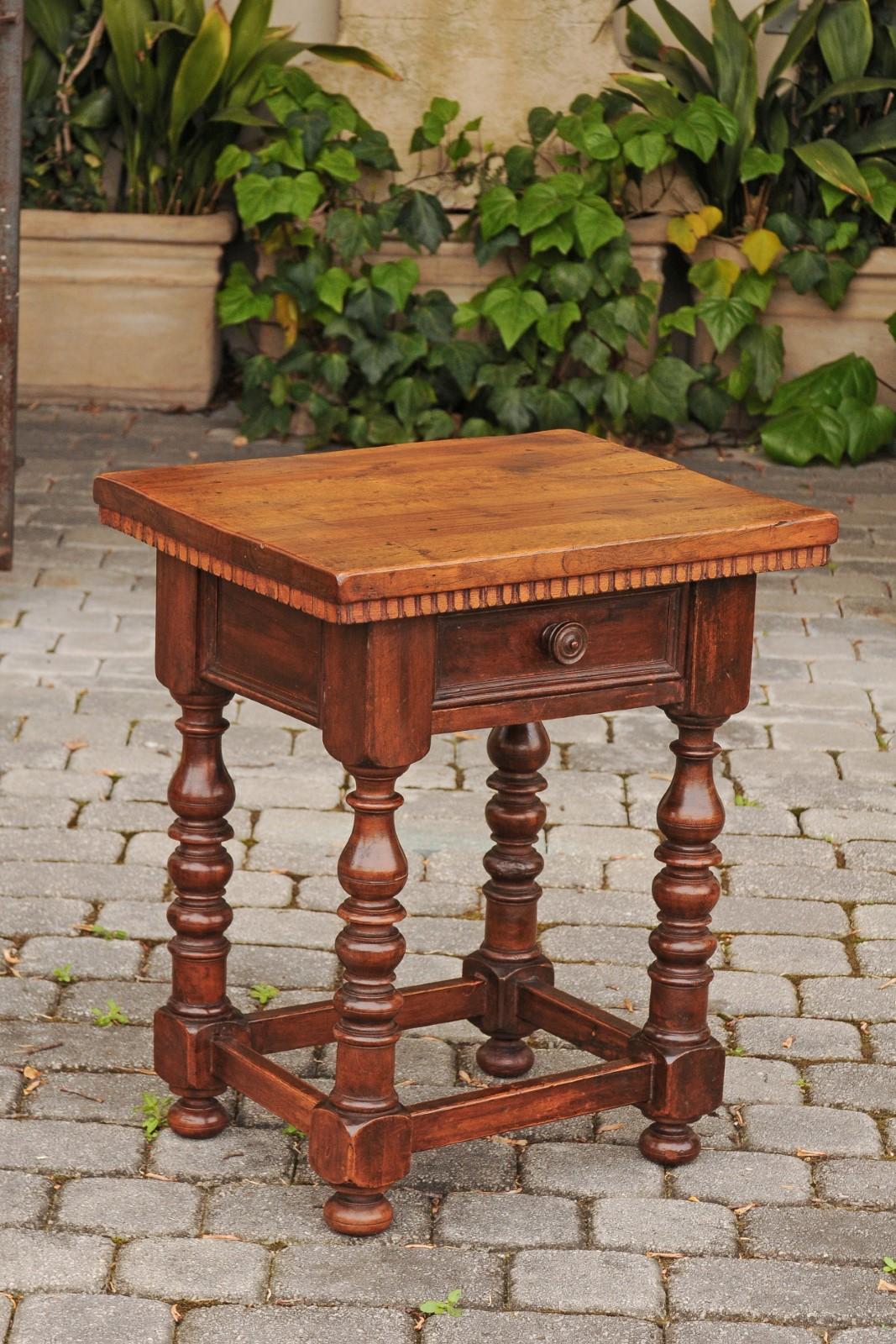 An Italian walnut side table from the late 19th century, with dentil molding and turned base. Born in Italy during the third quarter of the 19th century, this charming side table features a rectangular top, sitting above a dentil molding. The apron
