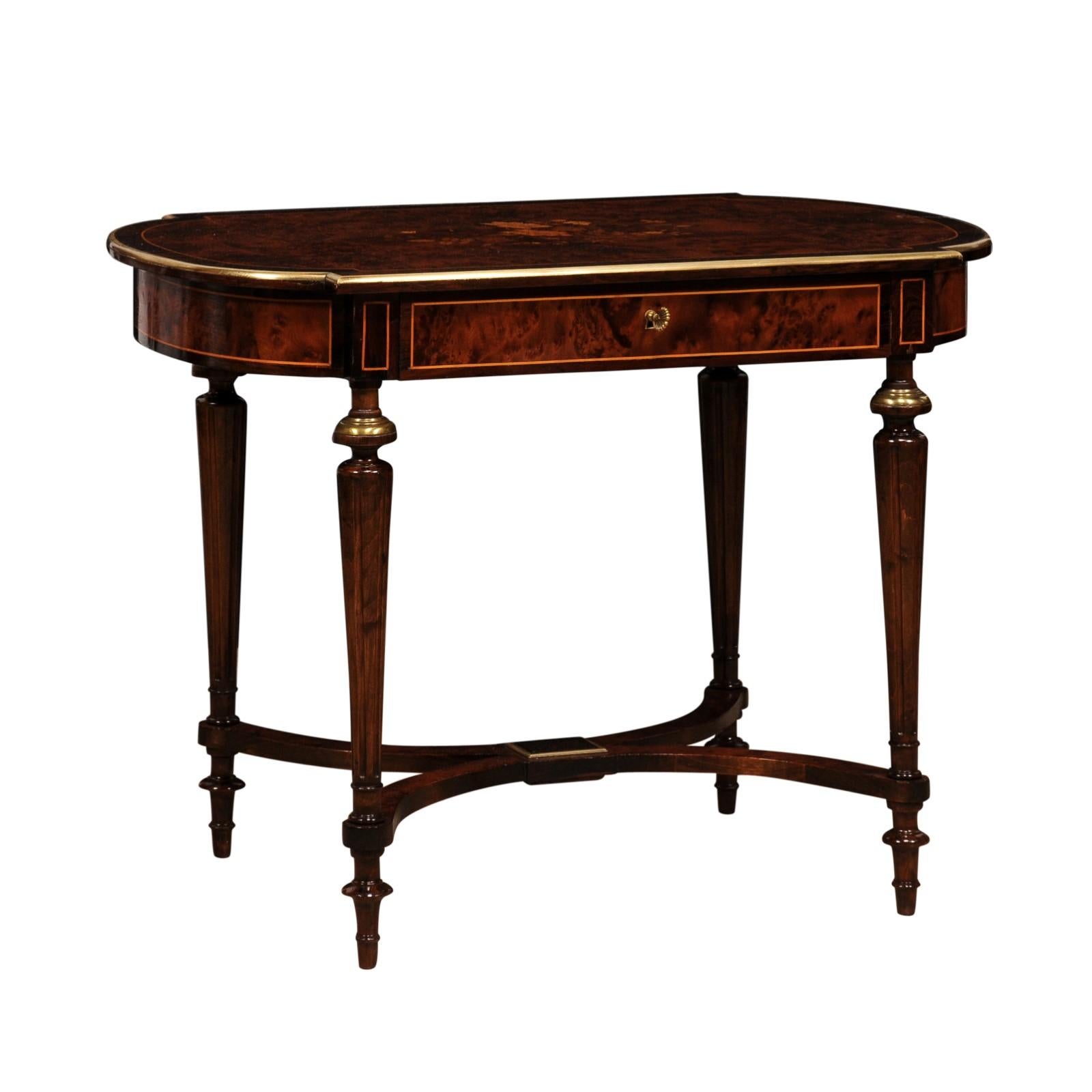 An Italian walnut and mahogany side table from circa 1890 with floral marquetry at the top, brass trim, single drawer, fluted tapering legs and X-Form cross stretcher. Discover the quintessence of Italian craftsmanship in this splendid walnut and