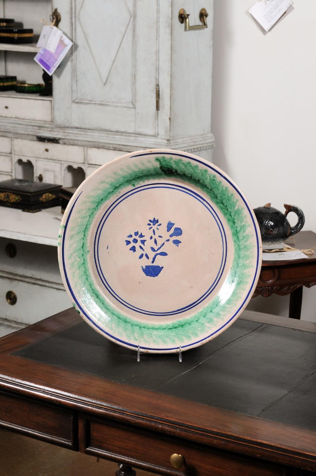 An Italian pottery platter from the late 19th century, with stylized blue floral motifs and green accents. Created in Italy during the late decade of the 19th century, this pottery platter features blue and green tones alternating with one another.