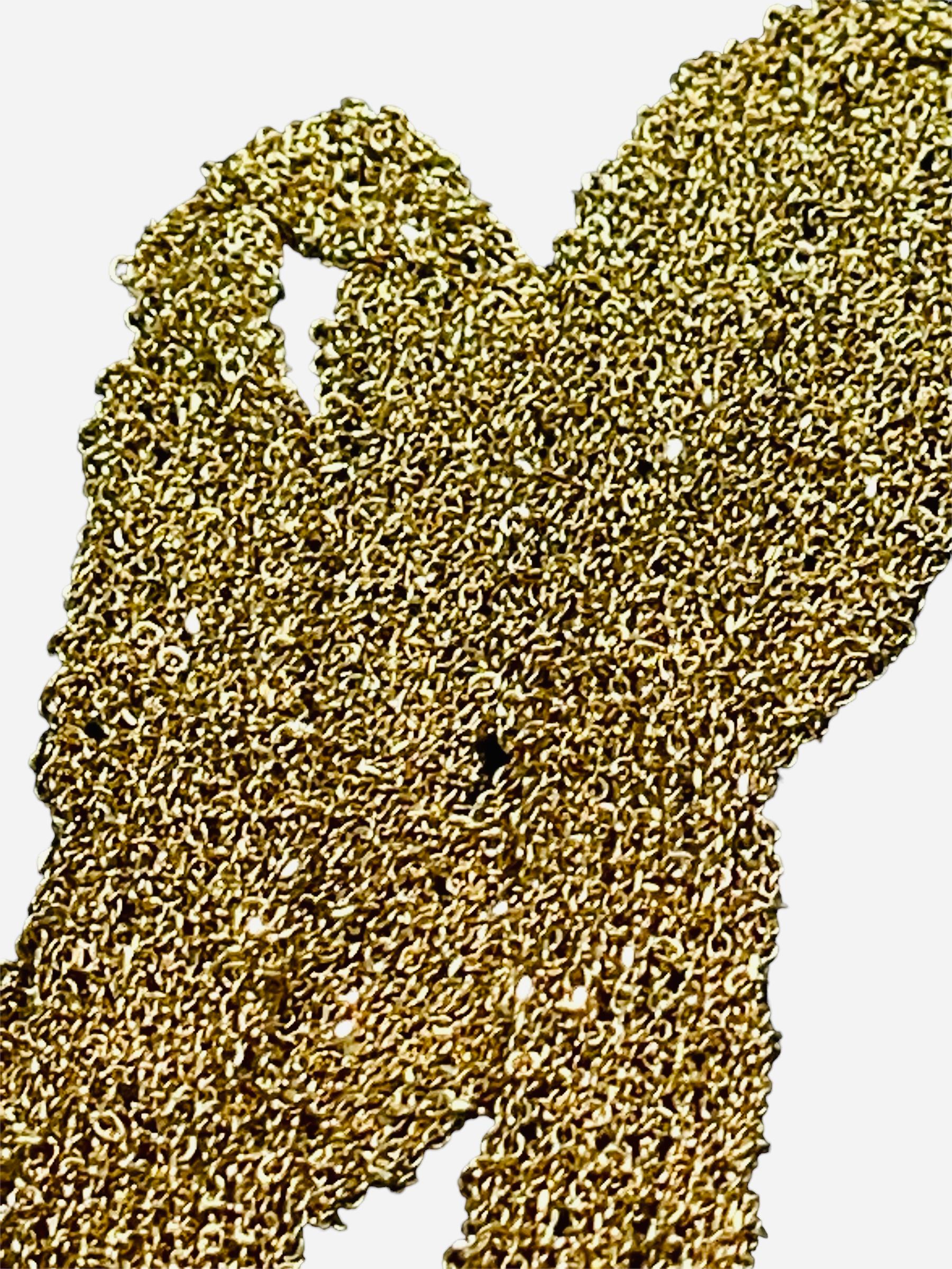 Si tratta di una collana lunga con nappe in oro giallo 18 carati. Il marchio è 750 e 2214/VI, rispettivamente dell'artigiano e della città (in questo caso Vicenza) in Italia, nella barra sopra la nappina.