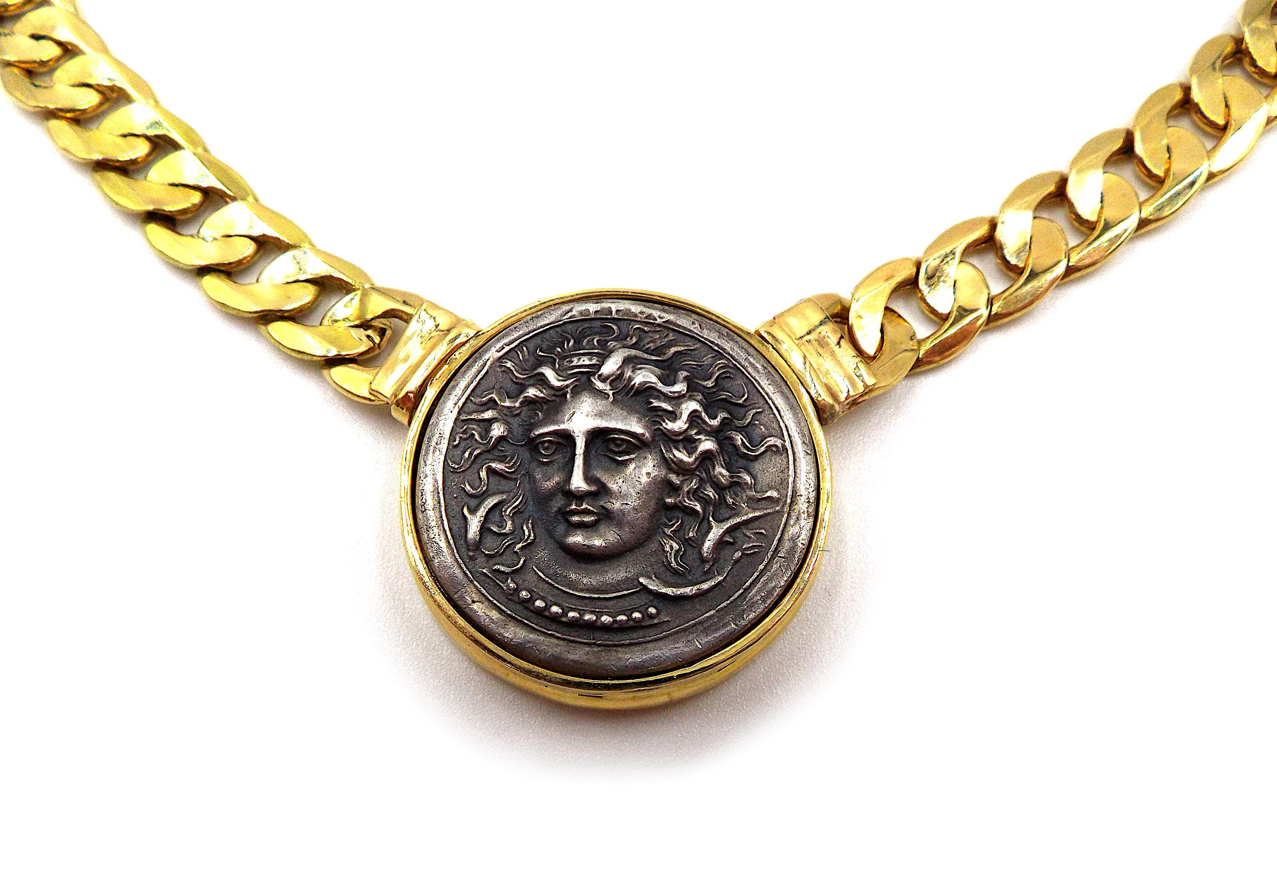 A vintage gold necklace featuring an ancient silver coin. With Italian registry marks, stamped 750. The necklace length is approximately 16.5 inches. Coin diameter is approximately 1 inch. Weight is 53.5 grams.