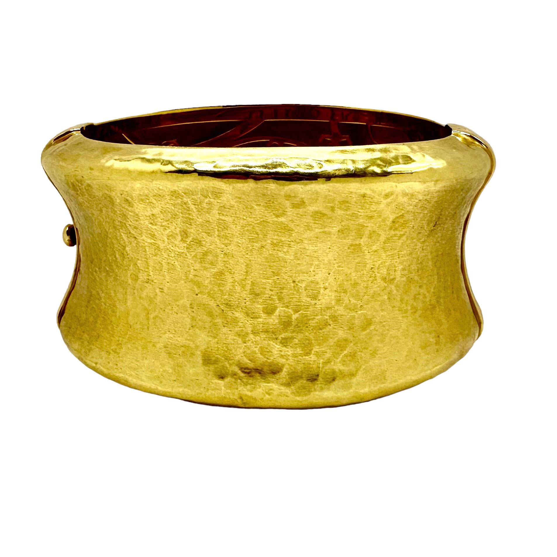 This wonderful vintage 18k yellow gold concave cuff bracelet measures a full 1 5/8 inches in width. With distinctive beveled edges and a dramatic hammered finish on the satin gold surfaces, plus the contrasting high polished seams, this unique