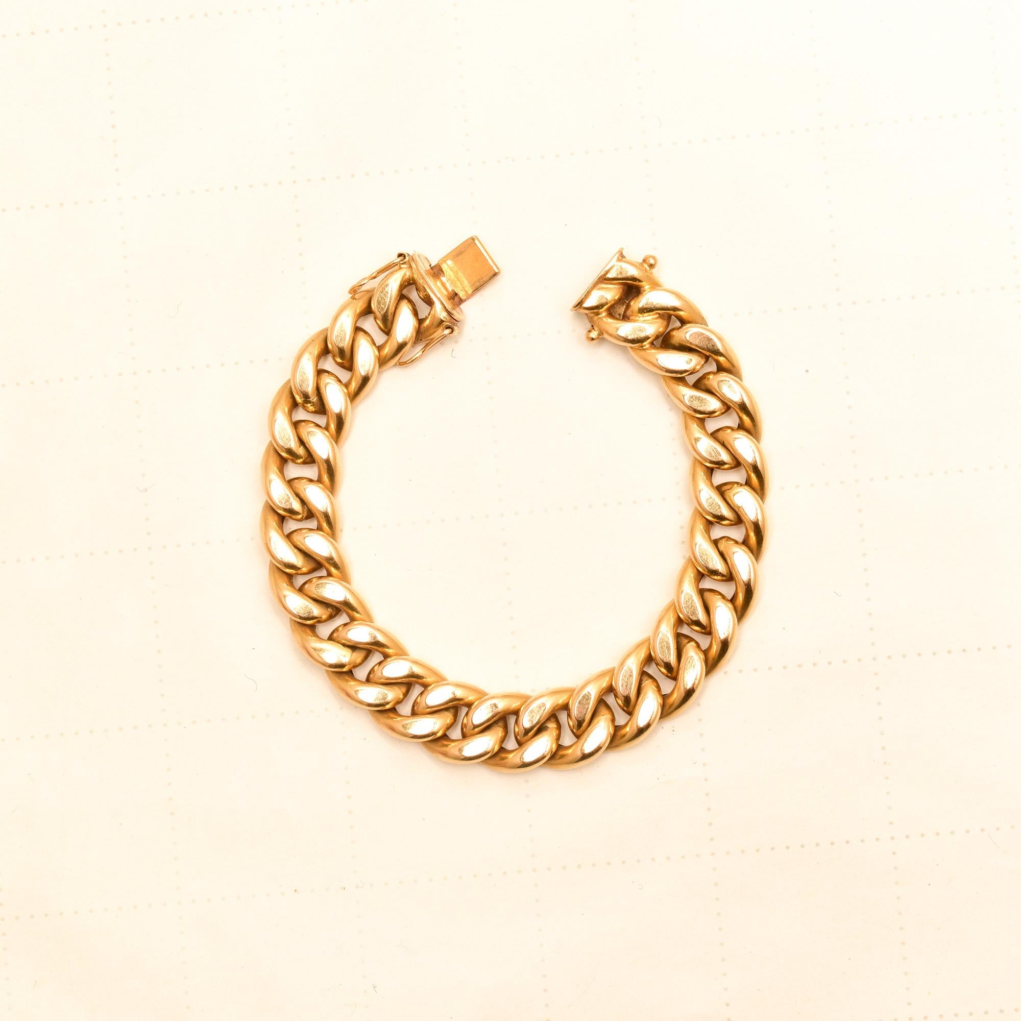 A robust 18K yellow gold cuban link bracelet made in Italy. Features a thick curb link style with a double security arm box clasp. The bracelet has a considerable weight with puffed links for a comfortable fit and feel. Typically a men's bracelet