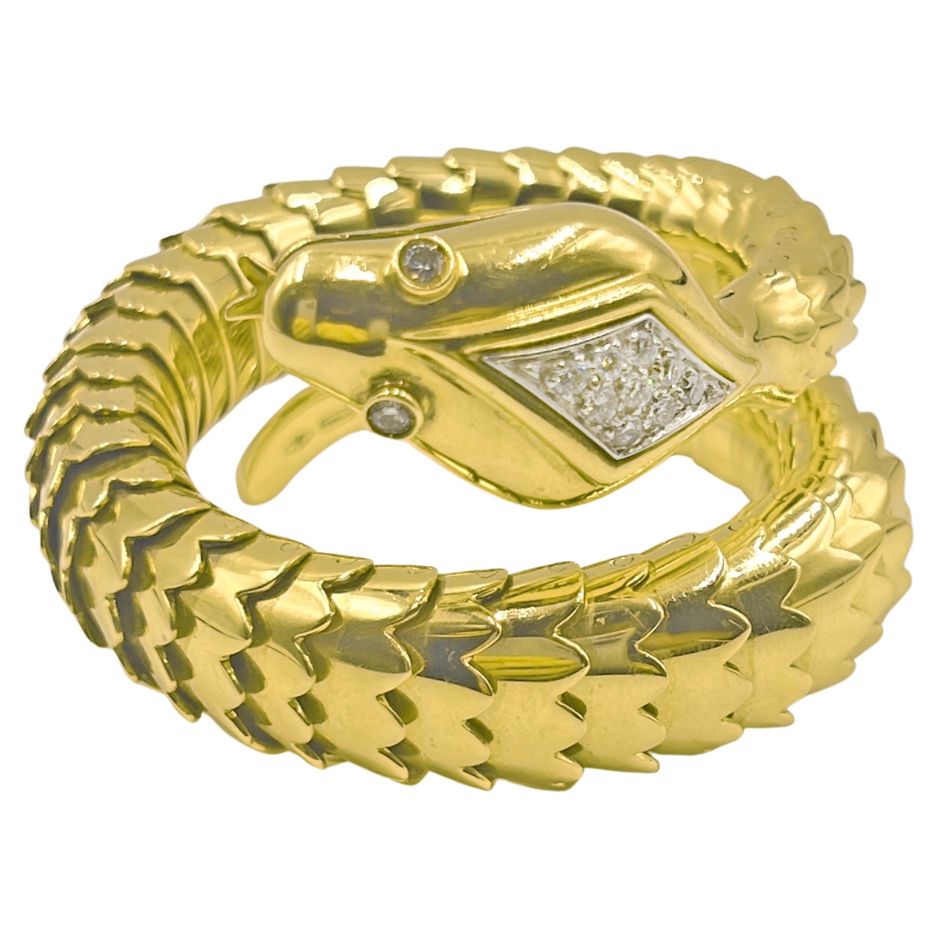 Italian coil snake design bracelet in polished 18k yellow gold. The flexible coil design gently wraps around the wrist with carefully articulated tapered scales. The top of the head is pave-set with nine diamonds and the eyes are bezel set with two