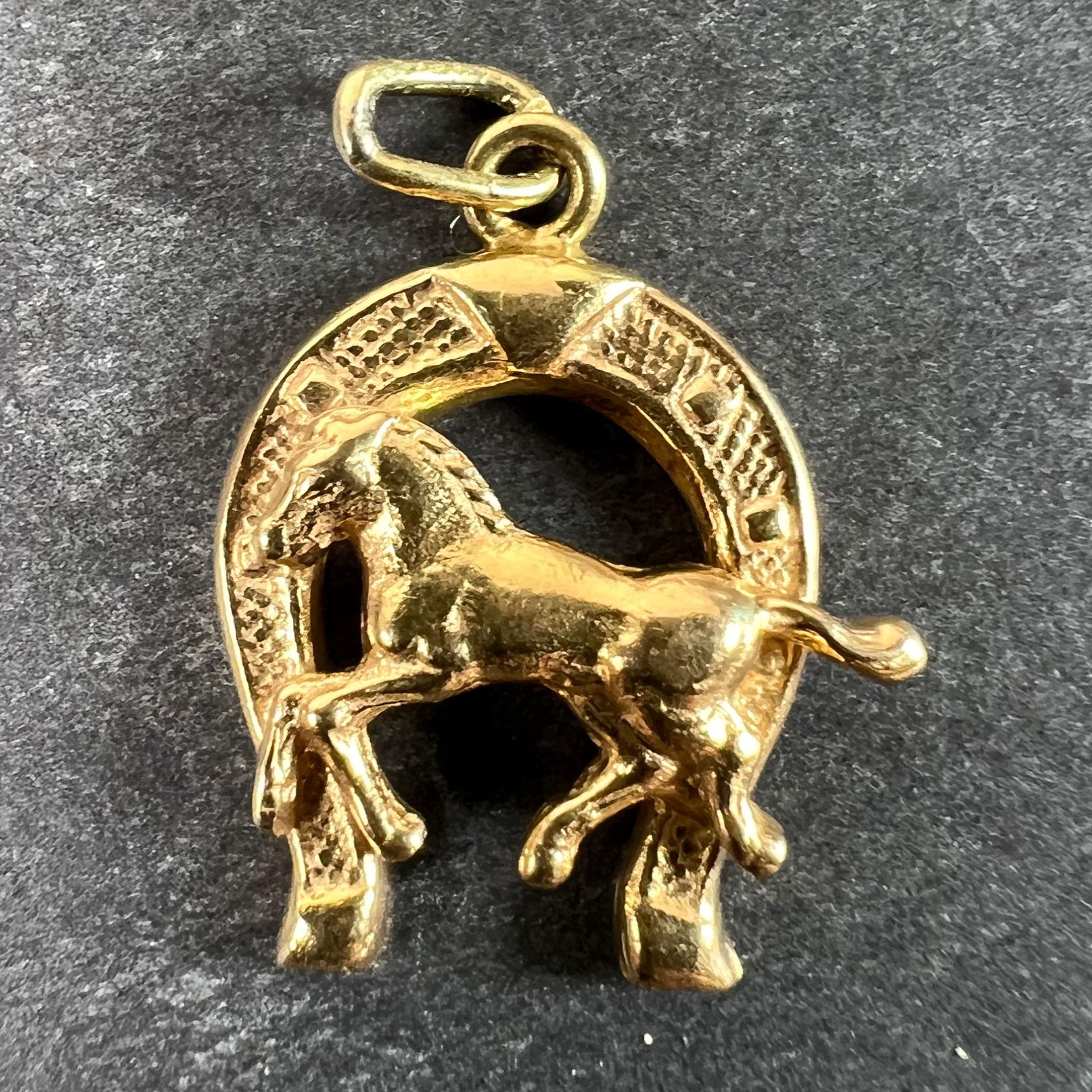 An Italian 18 karat (18K) yellow gold charm pendant designed as a lucky horseshoe with the figure of a horse in front of it. Stamped 750 for 18 karat gold and Italian manufacture with unknown maker's marks 16 AL.

Dimensions: 1.9 x 1.5 x 0.35 cm