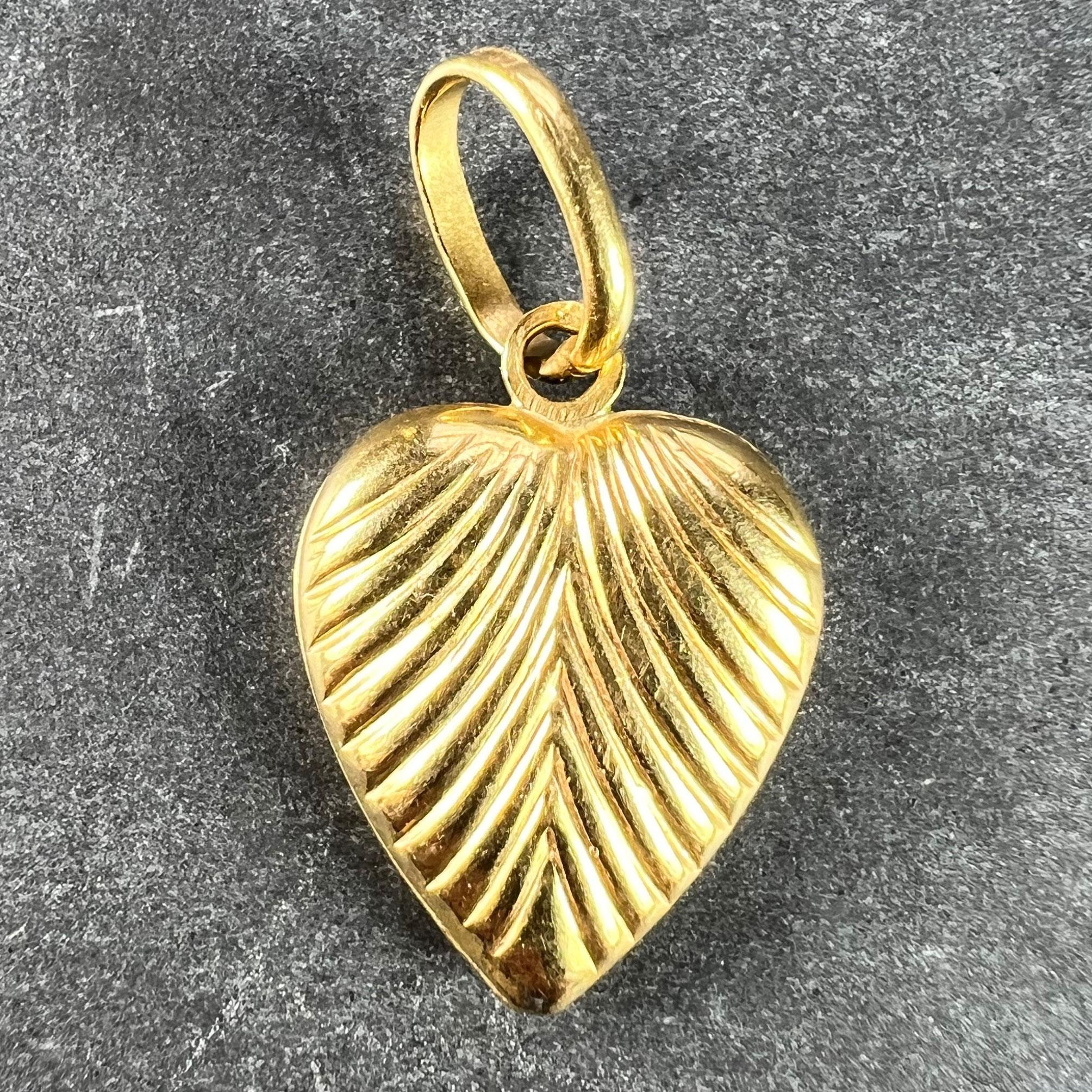 An Italian 18 karat (18K) yellow gold charm pendant designed as a puffy heart with scalloped ridges. Stamped 750 for 18 karat gold and 569VI for Italian manufacture.

Dimensions: 1.5 x 1.1 x 0.33 cm (not including jump ring)
Weight: 1.14