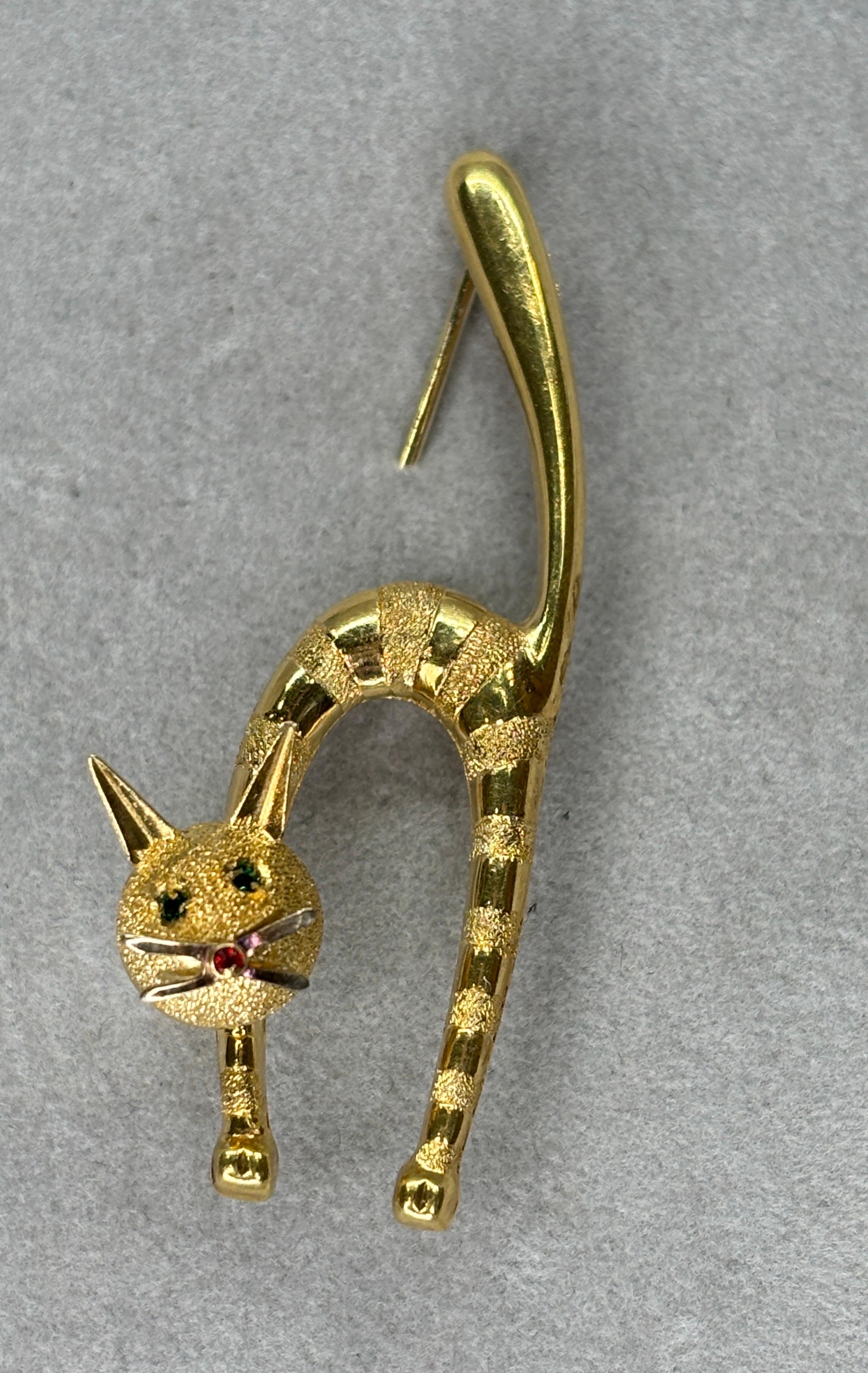This cat figure crafted in 18k yellow gold captures a funny, playful, pouncing stance. The craftsmanship involves meticulous detailing to bring out the texture of the cat’s fur, the delicacy of its paws, or even the whimsical curl of its tail.  The
