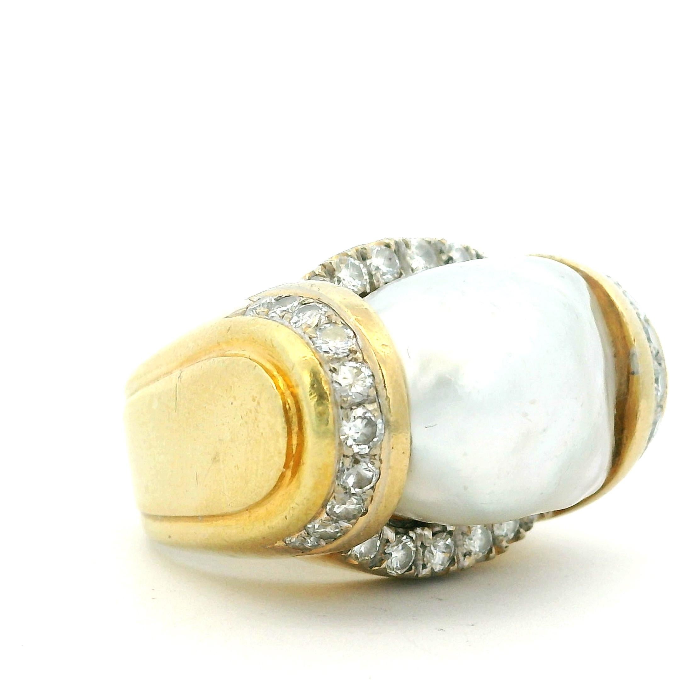 An exceptional Italian statement ring from the late 20th century, finely crafted in solid 18K yellow gold. At the center sits a luminous Australian South Sea baroque pearl, admired for its natural iridescence and unique organic form.
The pearl is