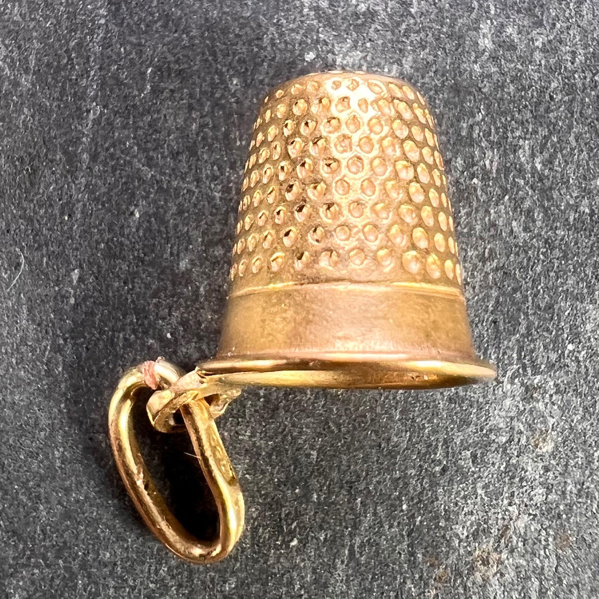 An Italian 18 karat (18K) yellow gold charm pendant designed as a thimble. Stamped 750 for 18 karat gold with an indistinct Italian maker's mark, along with French import marks for 18 karat gold.

Dimensions: 1 x 1.2 x 0.9 cm (not including jump