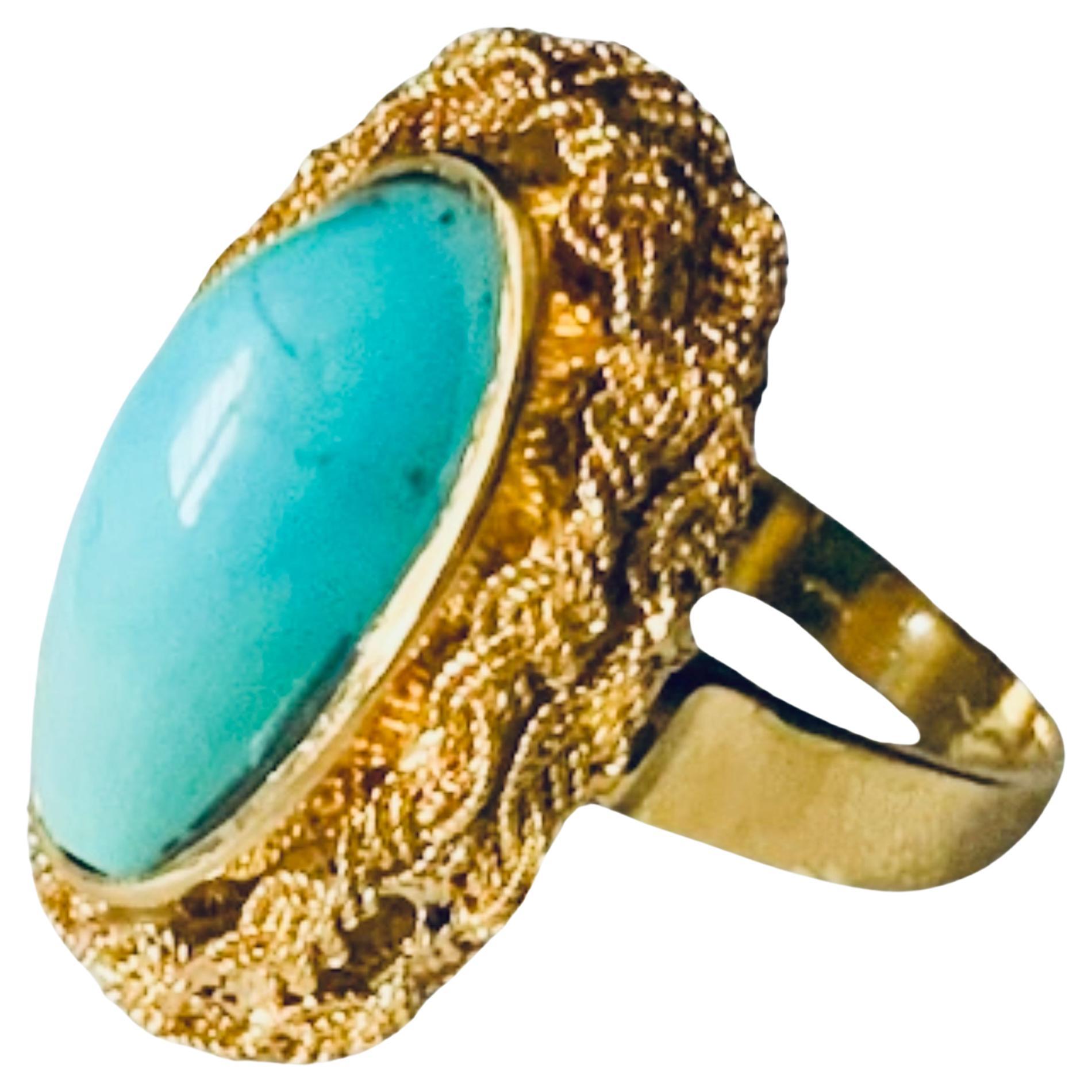 This is an Italian 18K yellow gold and Turquoise cocktail ring. It depicts an elongated oblong shaped cabochon Turquoise stone mounted in gold bezel setting and surrounded by a gold wreath made of double braided ropes. The Turquoise’s width and