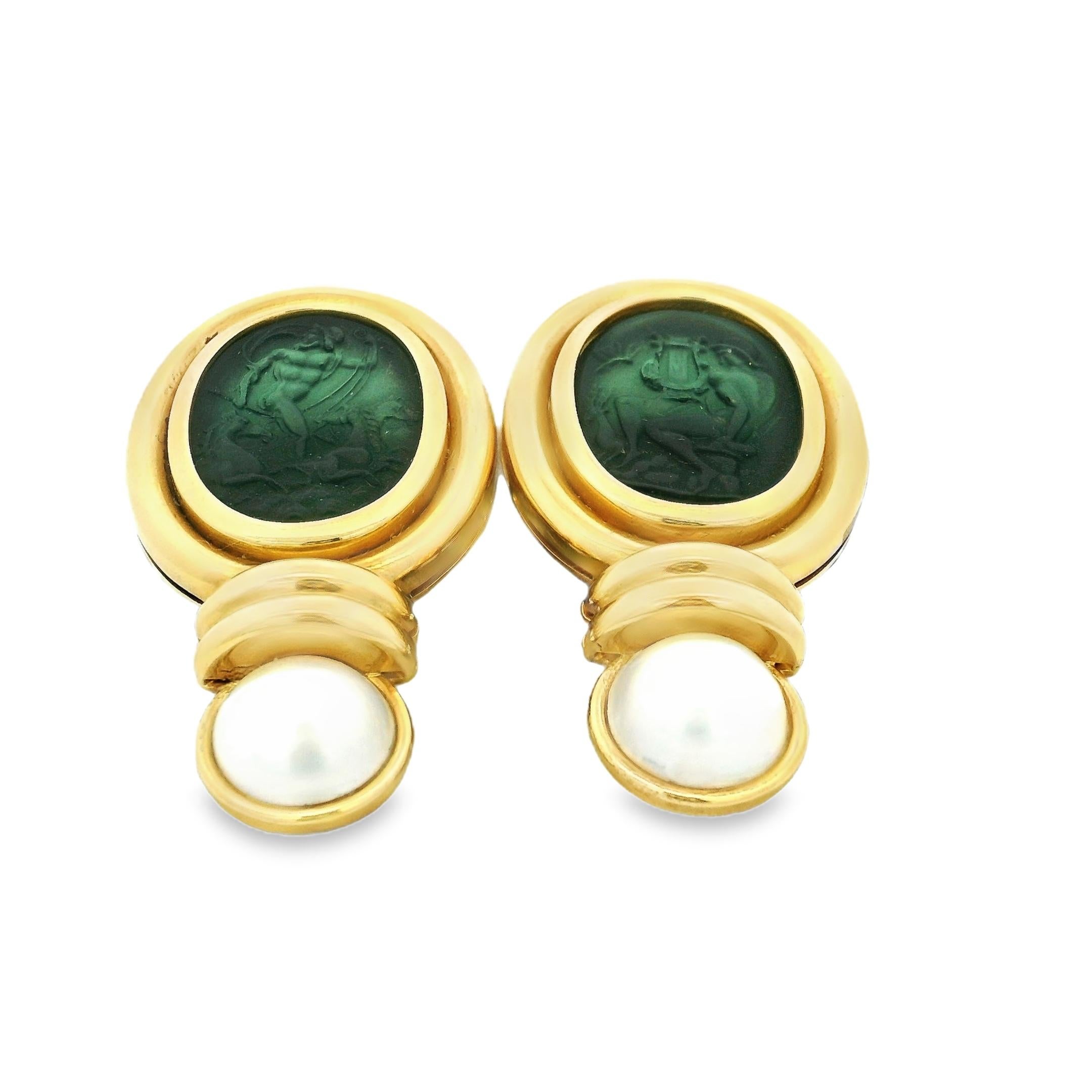 Uno straordinario paio di orecchini a clip italiani realizzati a mano in ricco oro giallo 18 carati, con intagli in vetro veneziano verde intenso con scene classiche e rifiniti con luminose perle coltivate bianche. La silhouette drammatica, audace