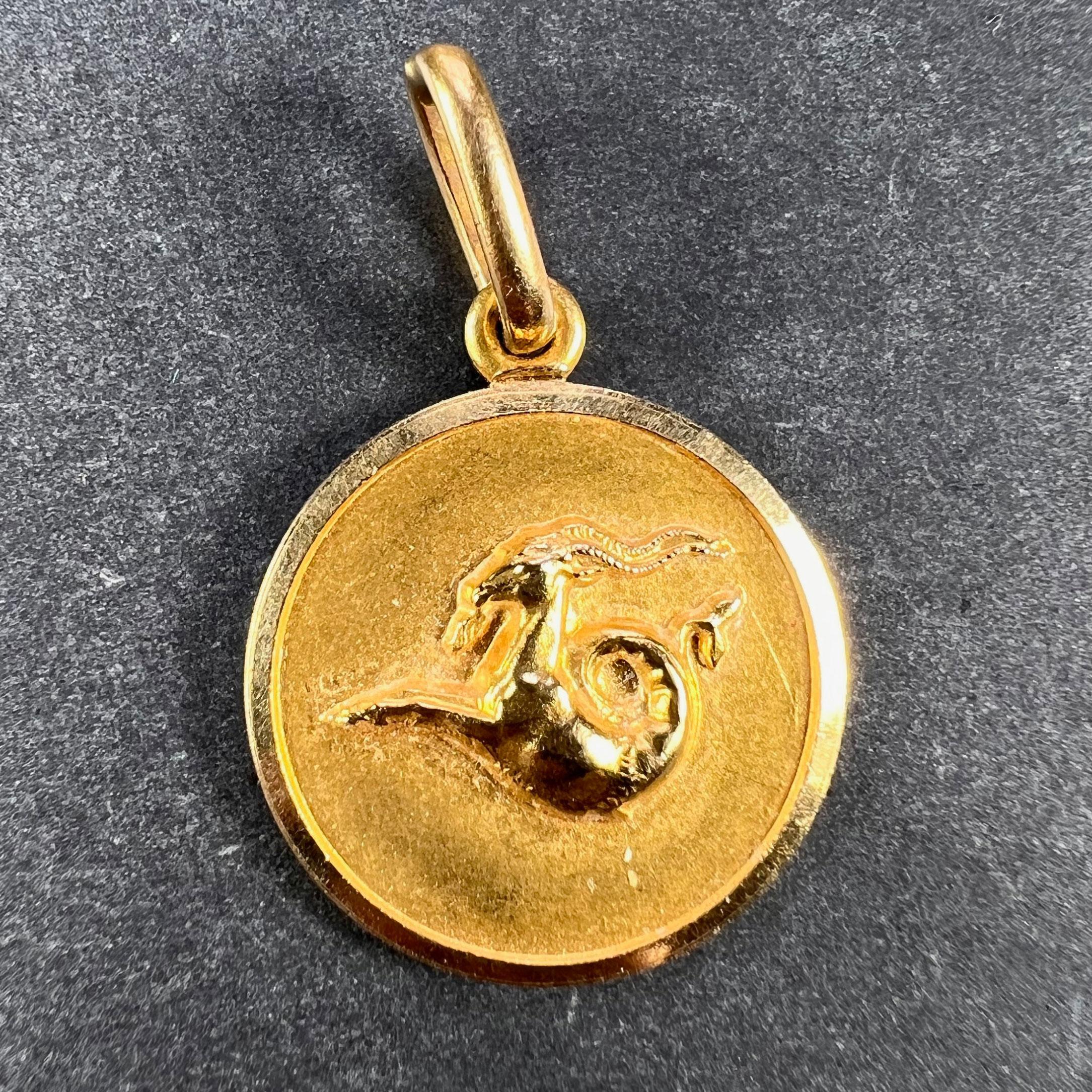 An 18 karat (18K) yellow gold charm pendant designed as the Zodiac sign of Capricorn in yellow gold within a circular frame. Stamped 750 for 18 karat gold and Italian manufacture with maker's mark 1AR for Unoarre.

Dimensions: 1.7 x 1.5 x 0.2 cm
