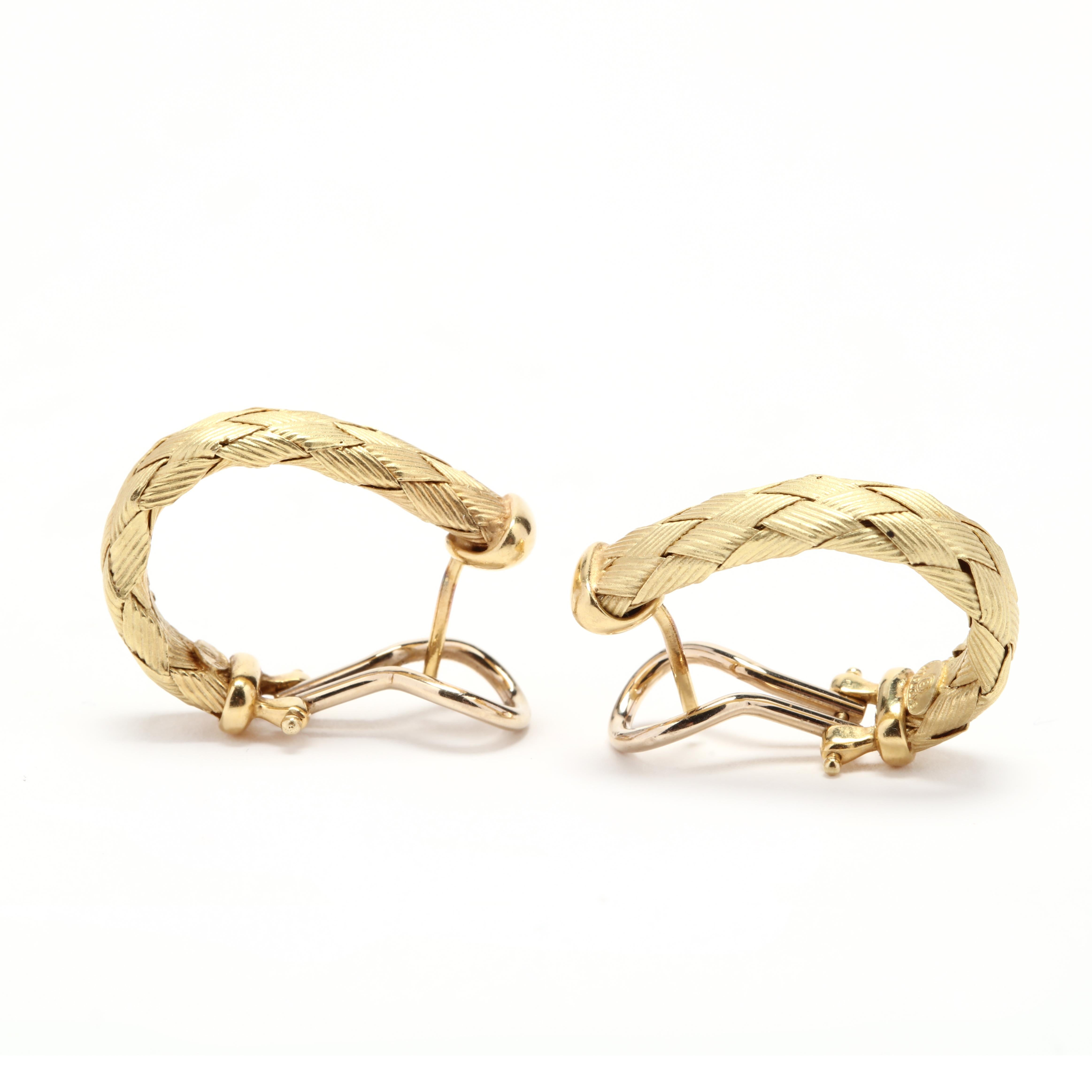 A pair of Italian 18 karat yellow gold woven hoop earrings. These earrings feature woven gold in a 'J' hoop design with pierced omega backs.

Length: 24 mm

Width: 5.5 mm

4.9 dwts.

* Please note that this is a vintage item and may show signs of