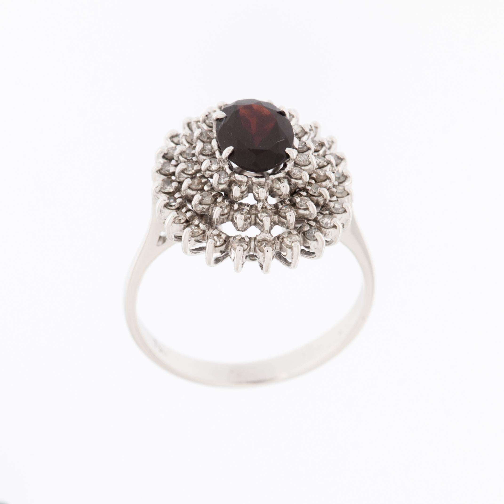 Der italienische 18-karätige Weißgold-Cocktailring mit Diamanten und Granat in Gefolge ist ein atemberaubendes und luxuriöses Schmuckstück. 

Dieser Ring ist aus 18 Karat Weißgold gefertigt, das für seinen Glanz und seine Haltbarkeit bekannt ist.