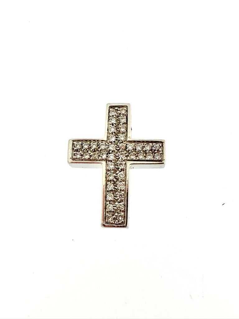 Cette magnifique croix italienne est entièrement en or blanc 18kt. La partie avant du pendentif est sertie de 20 diamants blancs taille brillant pour un total de 0,20ct. La technique utilisée est appelée 