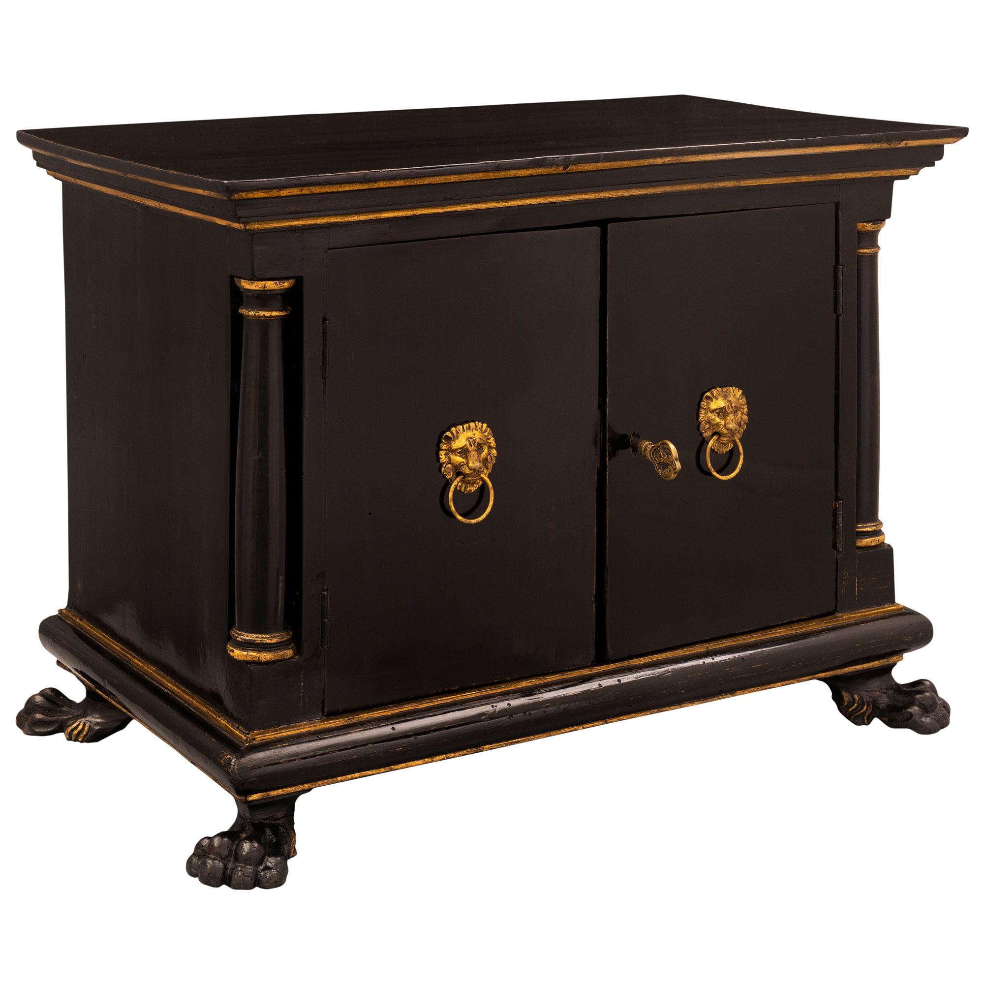 An exceptional Italian 18th century Baroque period ebonized fruitwood, Onyx de Fiorino, ormolu and giltwood miniature cabinet. The elegant small scale cabinet is raised by four richly carved paw feet below two central doors flanked by handsome