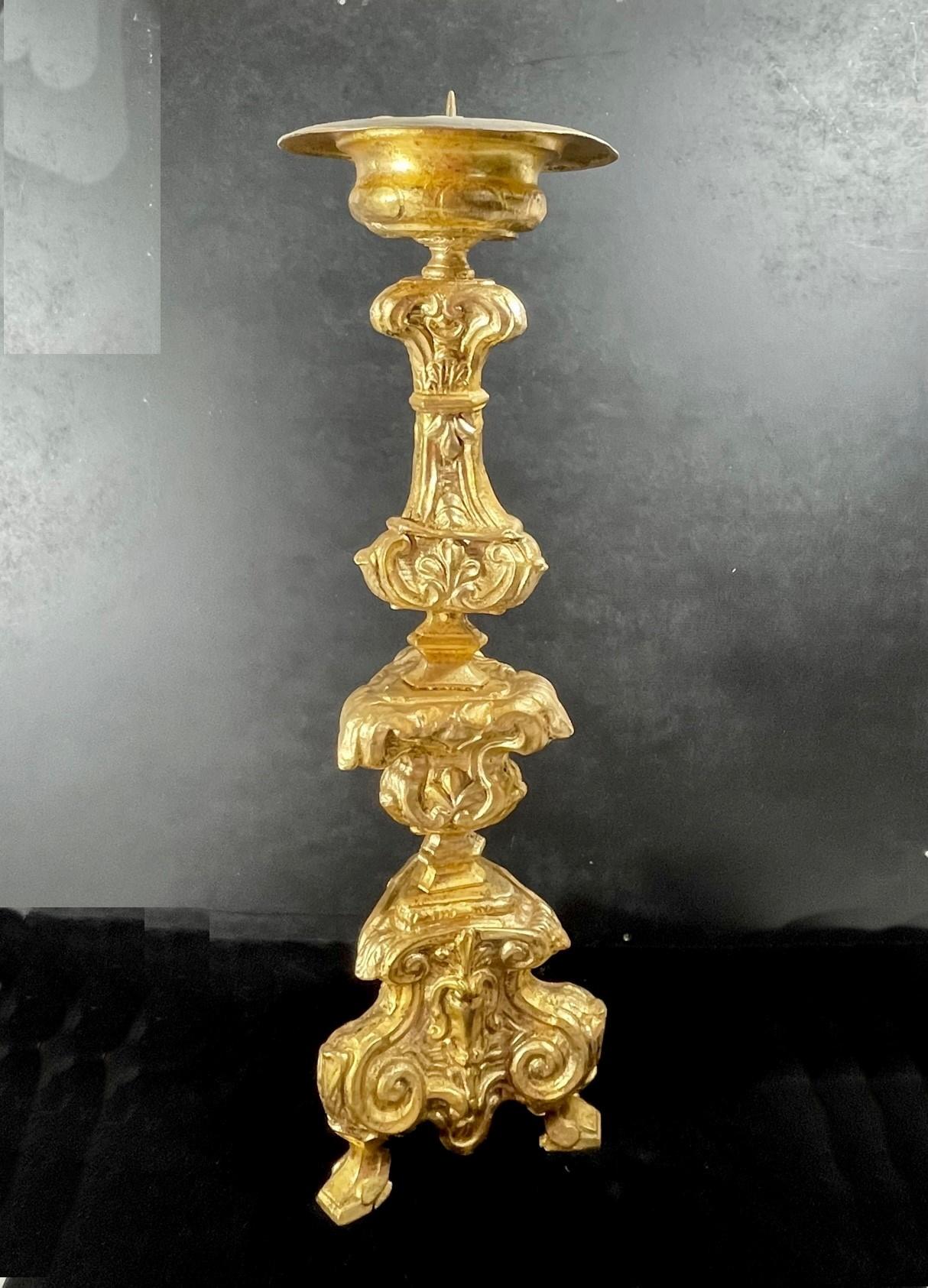 Italian 18th century Baroque gilt copper candlestick.

Rare Italian Baroque candlestick from the third quarter of the 18th century. It is a gilded copper body with a dished top on a baluster stem with scrolls and rocaills on a triform base. This