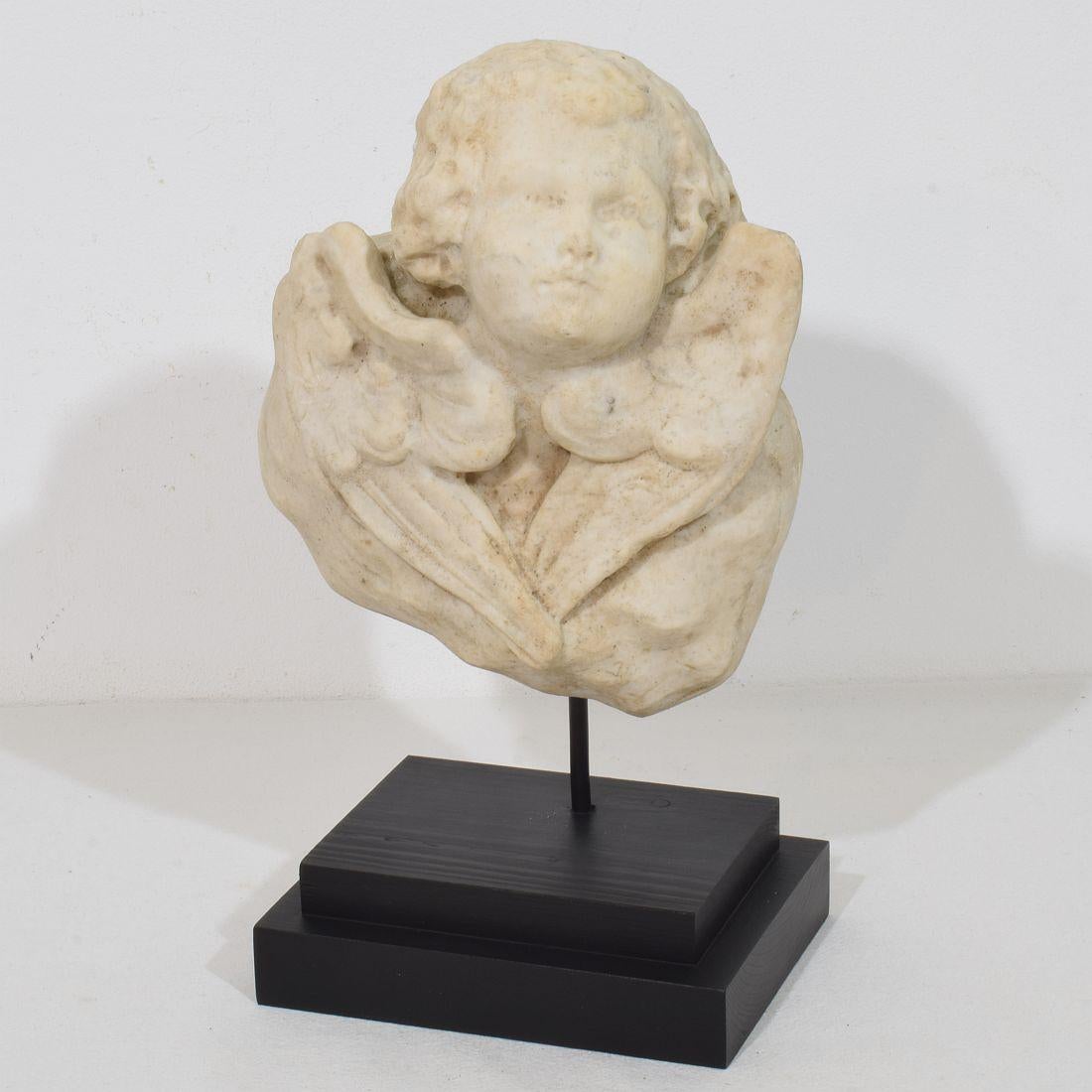 Beautiful weathered white marble angel head.
Italy, circa 1750. Good but weathered condition
Measurement here below includes the wooden pedestal.
H:29,5cm  W:19cm D:12cm 