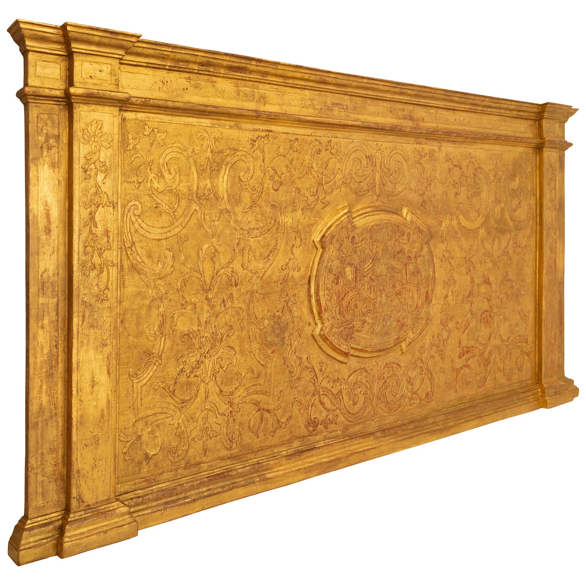 Un superbe panneau de décoration murale en bois doré italien du XVIIIe siècle de style baroque. Au centre de ce panneau très décoratif se trouve un médaillon central en saillie avec des motifs feuillus sculptés et des gerbes de feuilles d'acanthe,