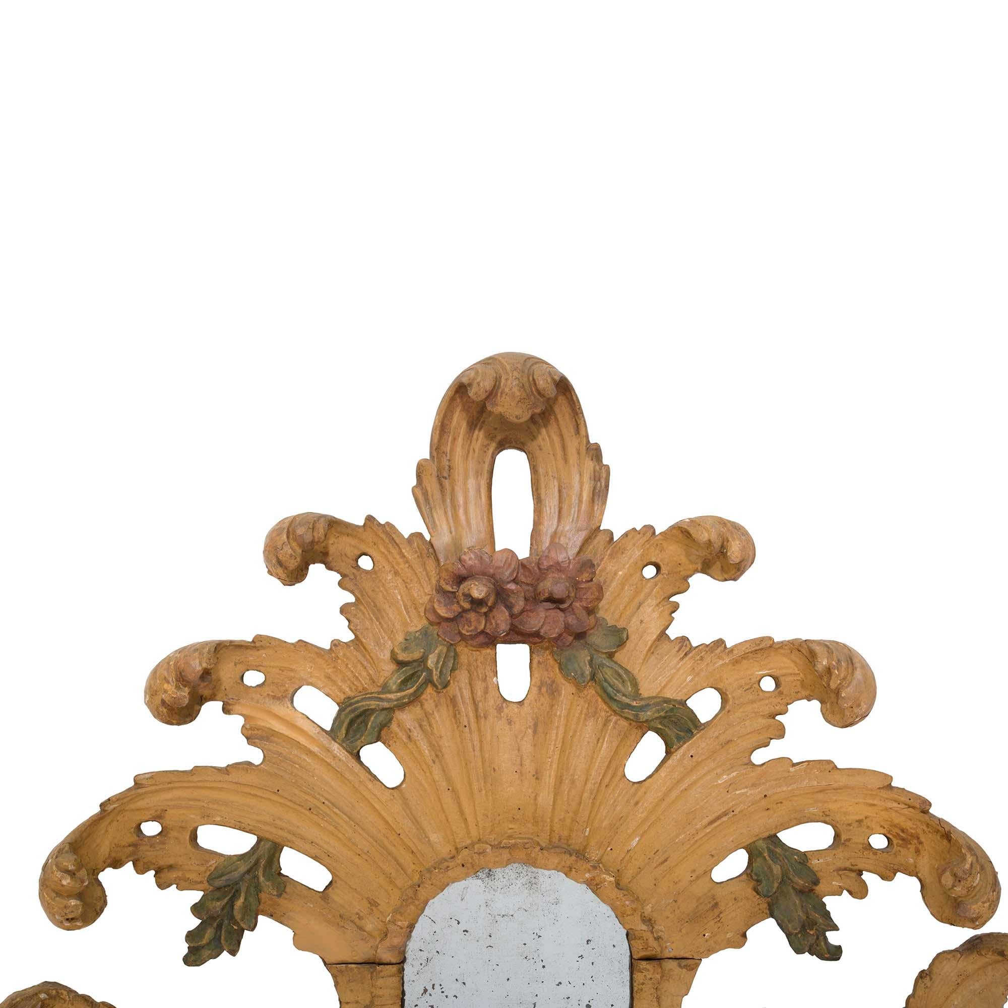 A beautiful and most unique Italian 18th century Baroque period polychrome mirror. The original mirror plates are framed within most decorative and richly carved polychrome borders with mottled designs and fine scrolled filiate movements. Extending