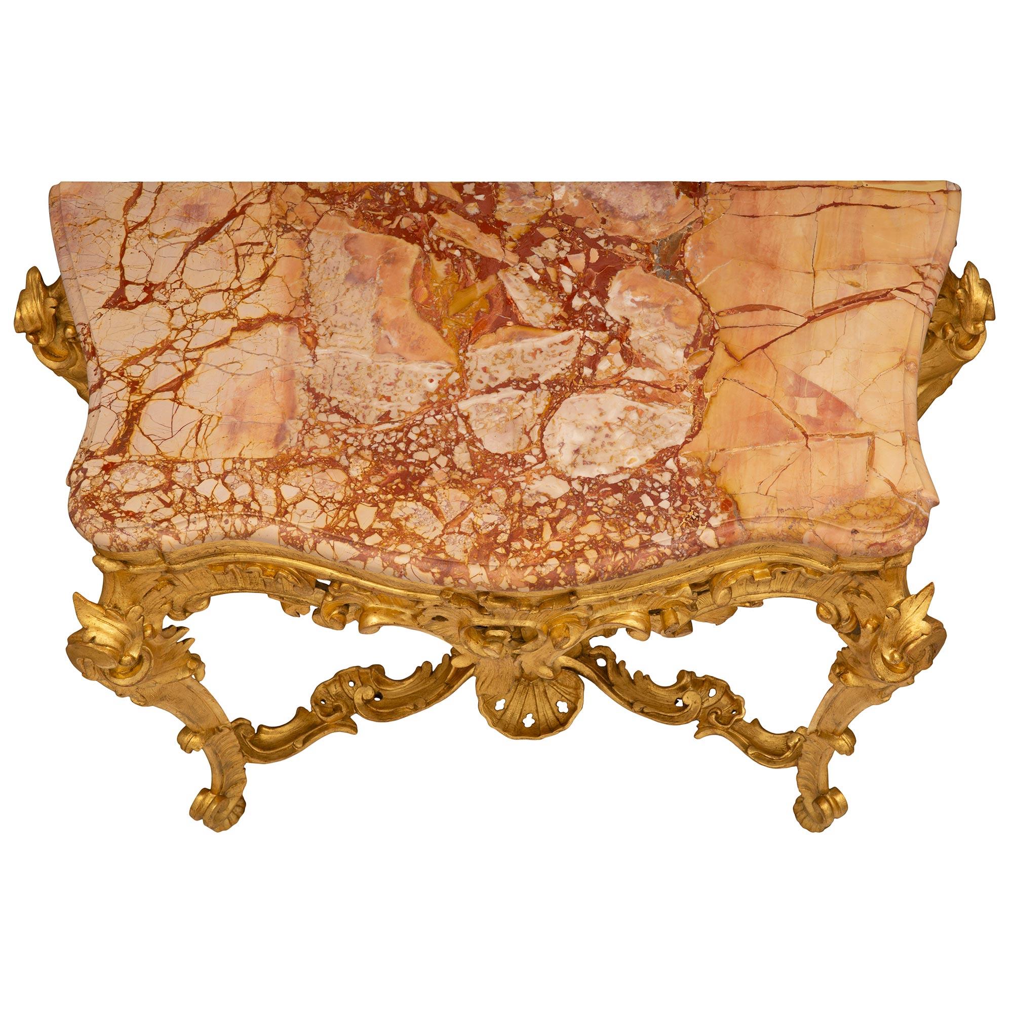 A magnificent Italian 18th century Baroque st. giltwood and Sarrancolin marble console. The freestanding console is raised by elegant cabriole legs with graceful fluted feet and richly carved foliate designs each connected by an impressive and most