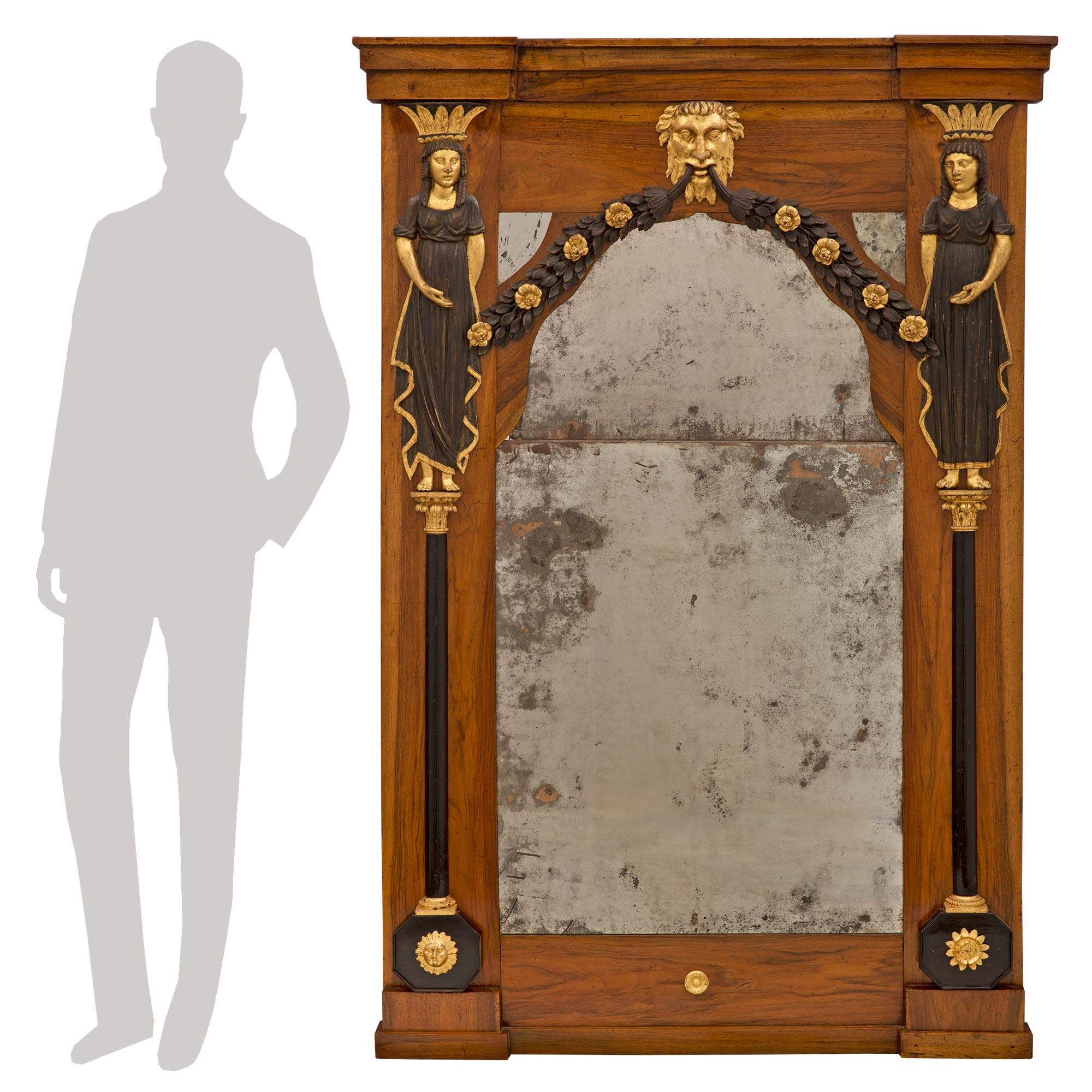 An exceptional Italian 18th century neo-classical st. walnut, giltwood, ebonized fruitwood and polychrome mirror. The mirror retains all of its original mirror plates throughout framed within a fine walnut border. Striking architectural columns