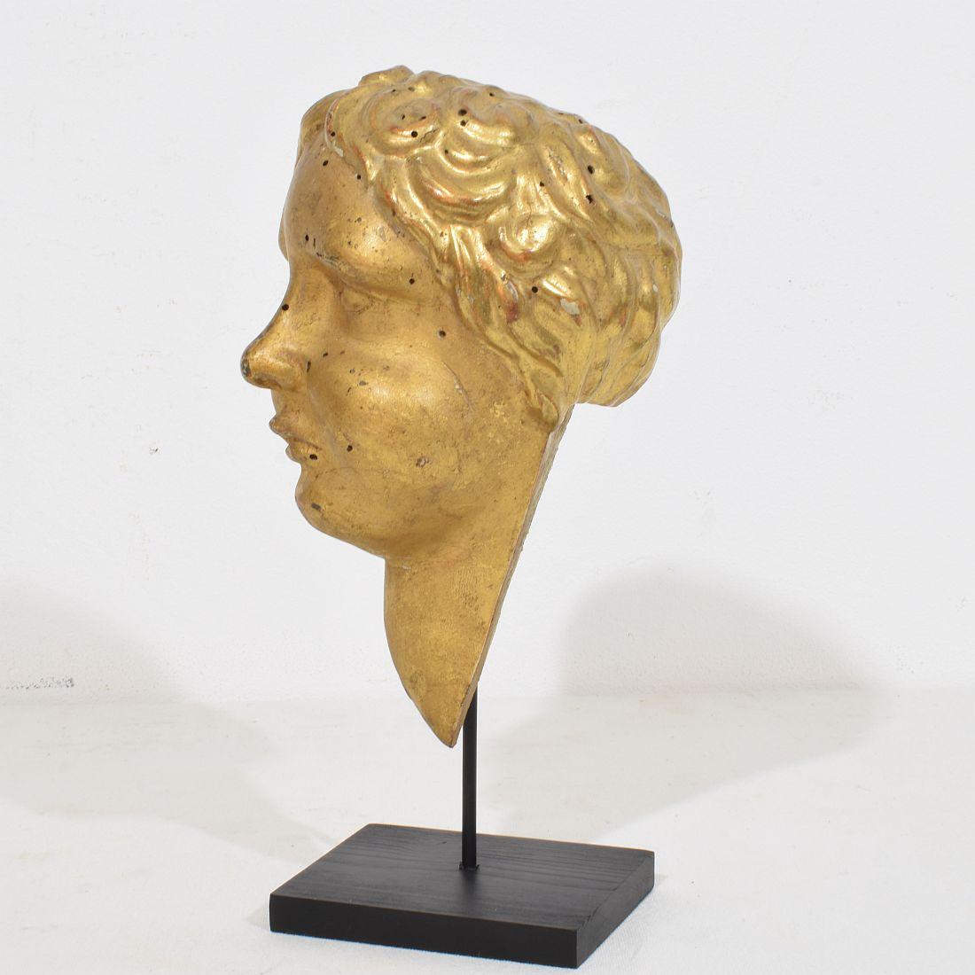 Precioso fragmento de cabeza de ángel de madera dorada
Italia, hacia 1750
Envejecido. 
Medida aquí abajo incluida la base de madera.
H:22,5cm  Anch:11cm Prof:10cm 