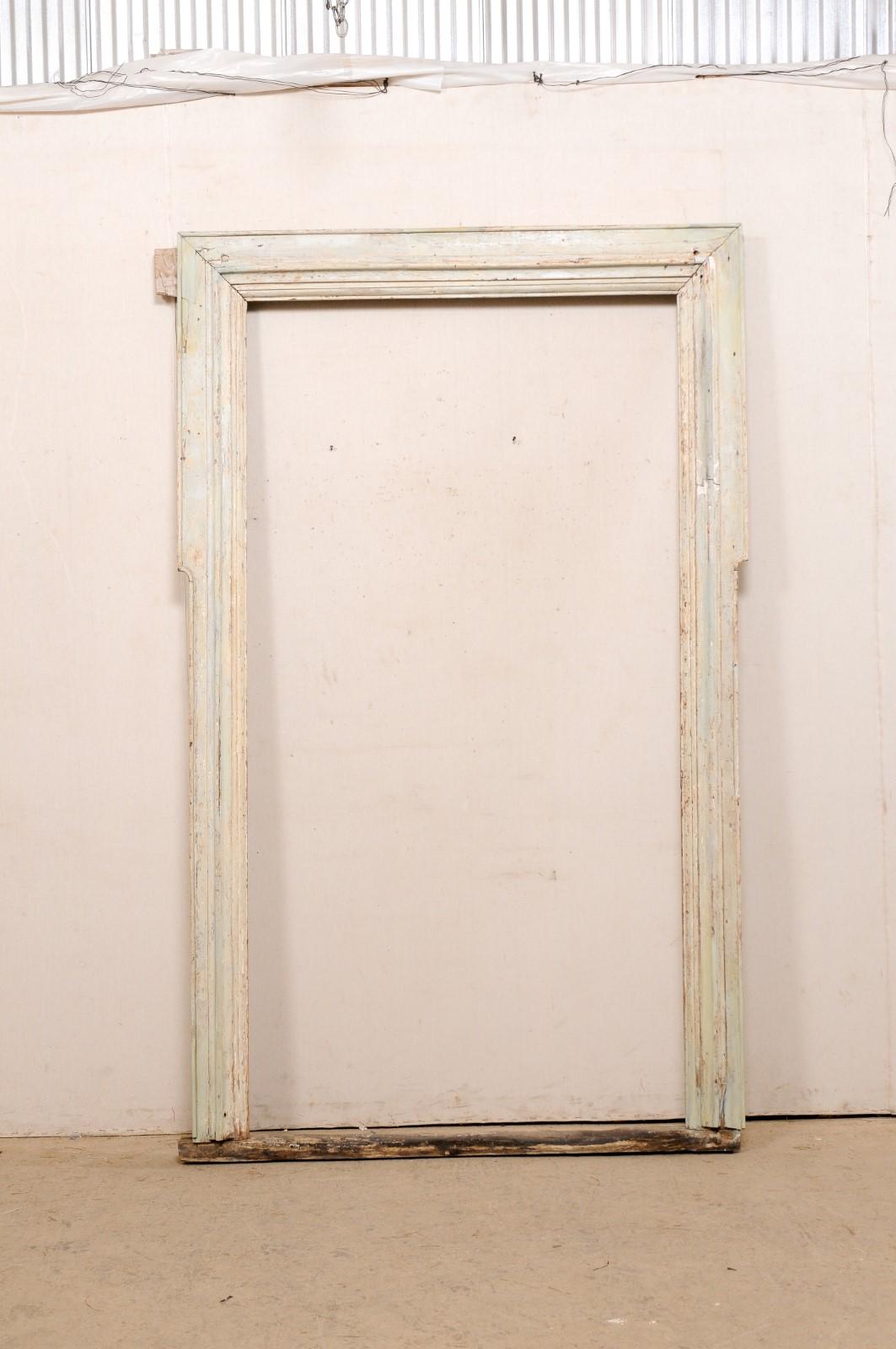 An Italian wooden entryway or doorway casement from the 18th century. This antique architectural piece from Italy is an interior doorway casing, which stands approximately 7.5 feet tall (including the upper molding). The molded wood is primarily