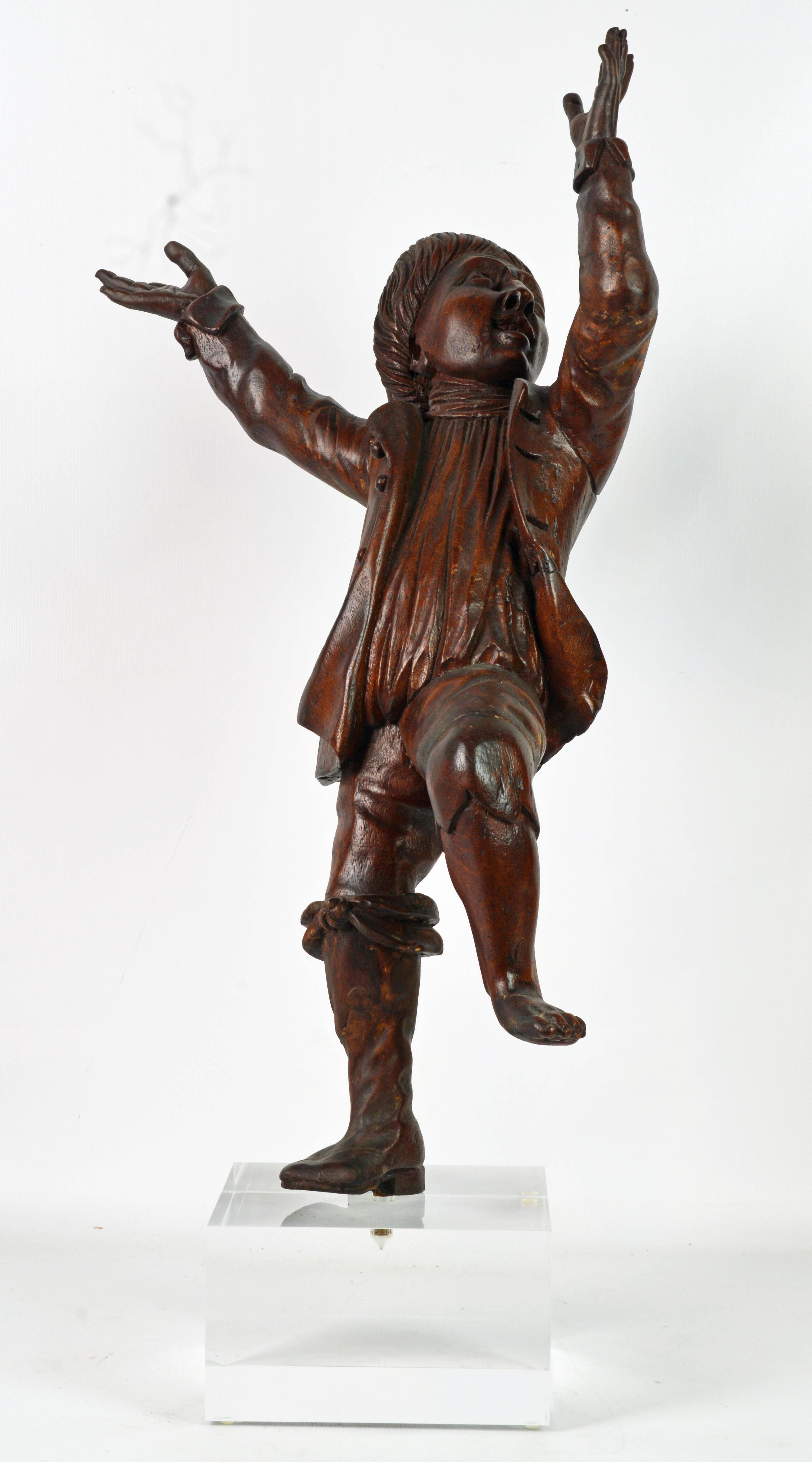 Standing more than 30 inches tall including the modern Lucite base this Italian figure features great movement of form and a sense of jubilant joy. The boy is wearing the traditional French hat, a well detailed frock, linen shirt and an adorned boot