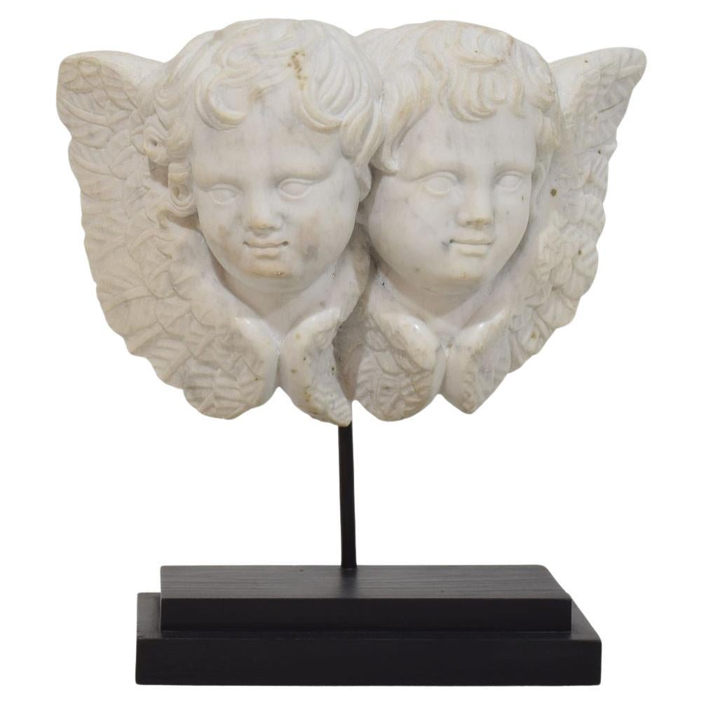 Ornement italien du 18ème siècle en marbre blanc sculpté représentant deux têtes d'anges ailés en vente