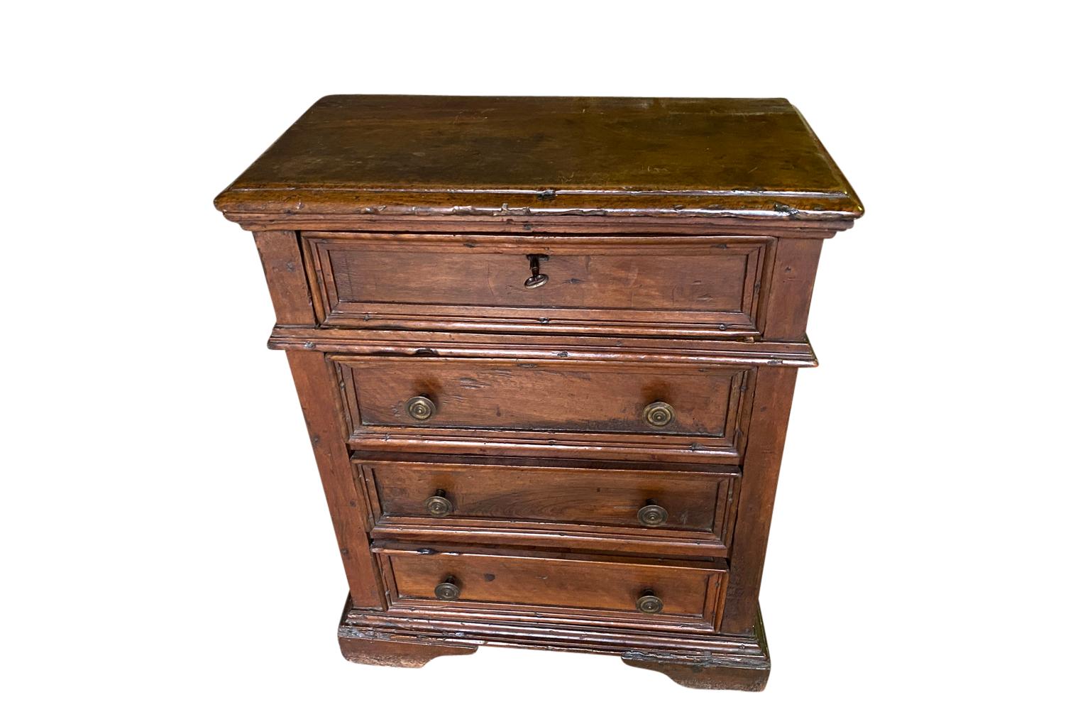 A striking 18th century Comodini from the Lombardy region of Italy. Handsomely constructed from solid walnut with a rectangular top atop a case housing four drawers with antique patinated brass pulls raised on bracket feet.