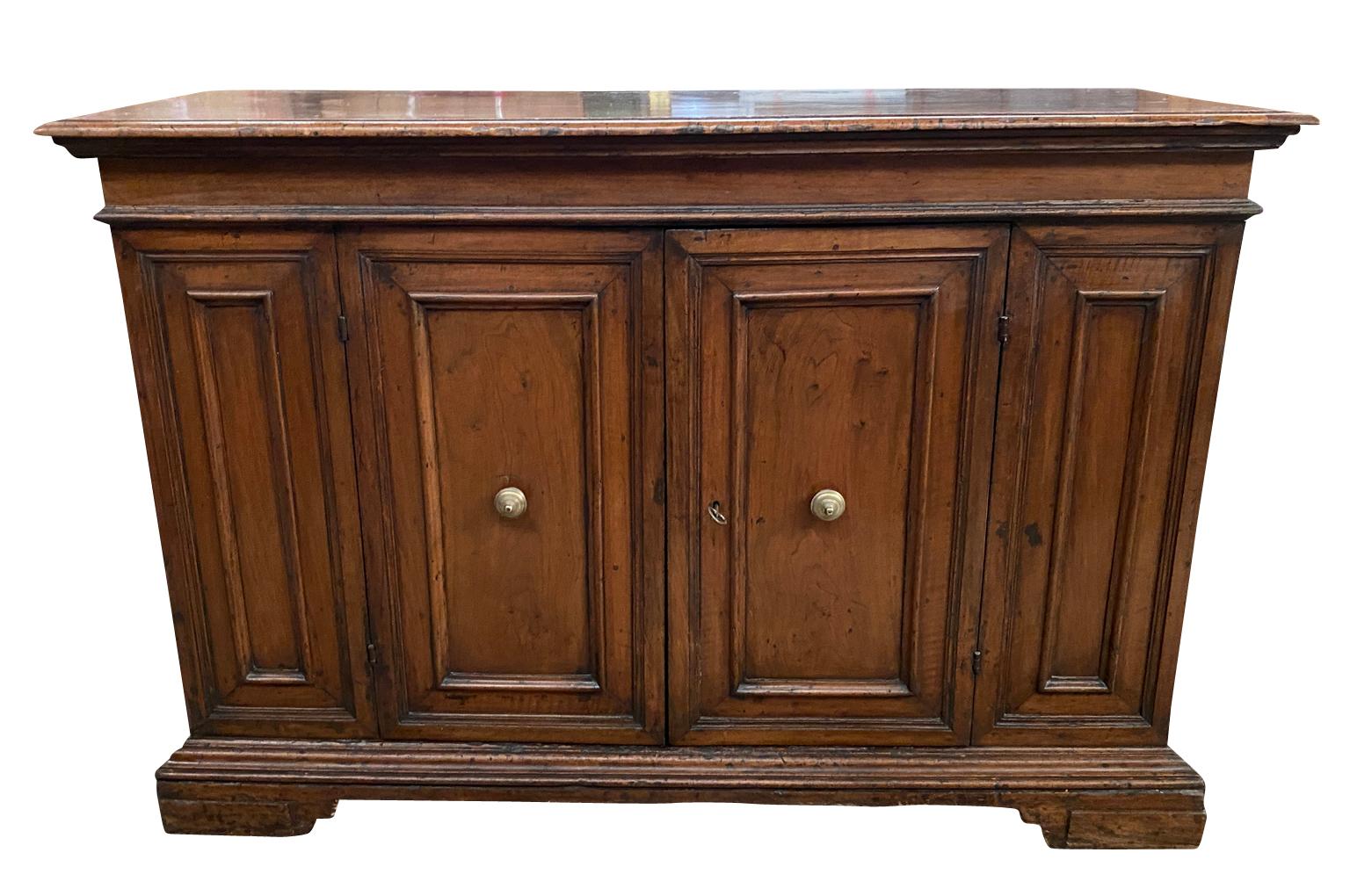 A stunning 18th century Credenza from the Lombardy region of Italy. Soundly constructed from handsome walnut with 2 doors, molded panels resting on bracket feet. Beautiful patina - warm and luminous.