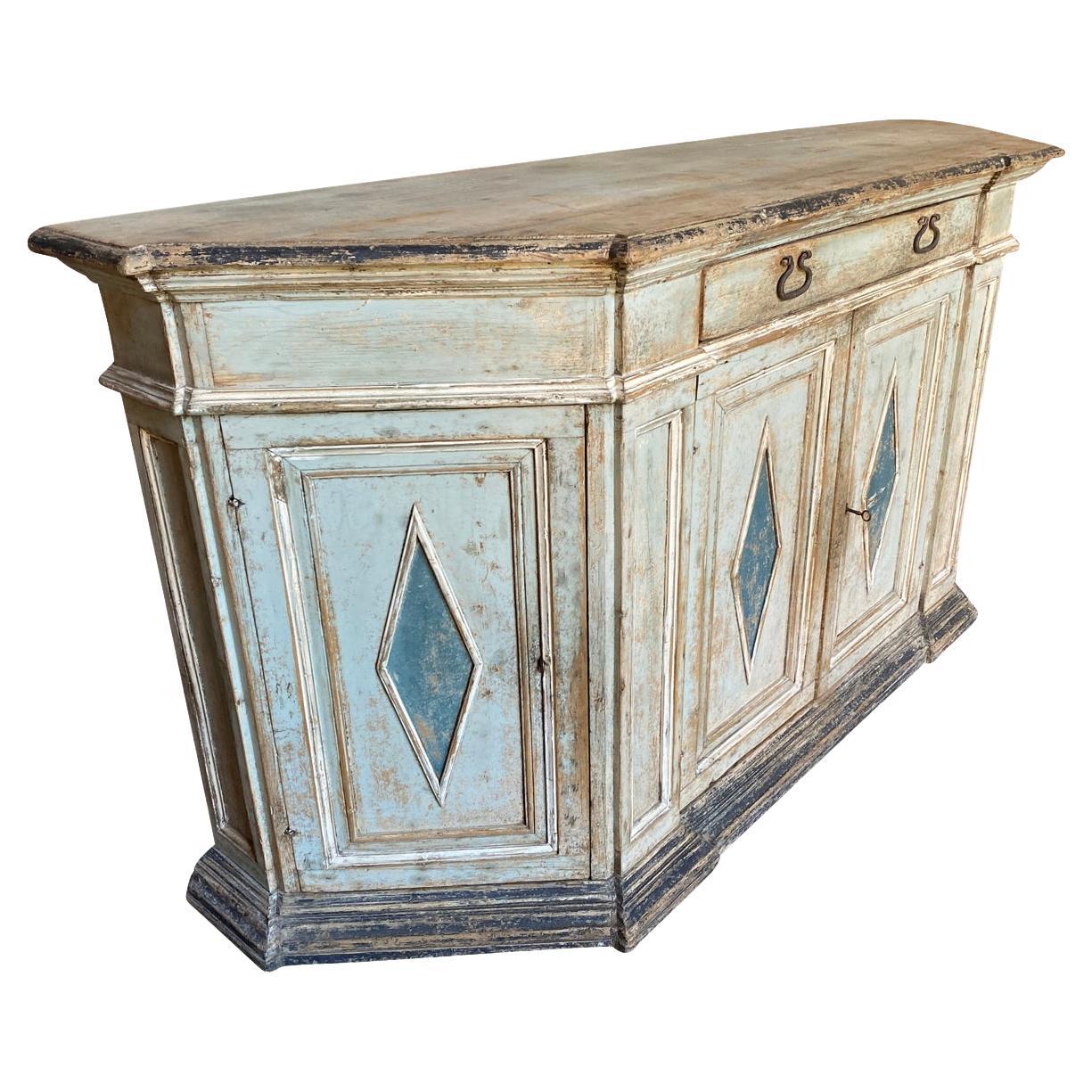 A stunning 18th century Cedenza from Bologna, Italy. Soundly constructed from painted wood in scantonata form, handsome edge finish to the top plank, a single drawer, four doors, interior shelving resting on its plinth base. Wonderful charm and