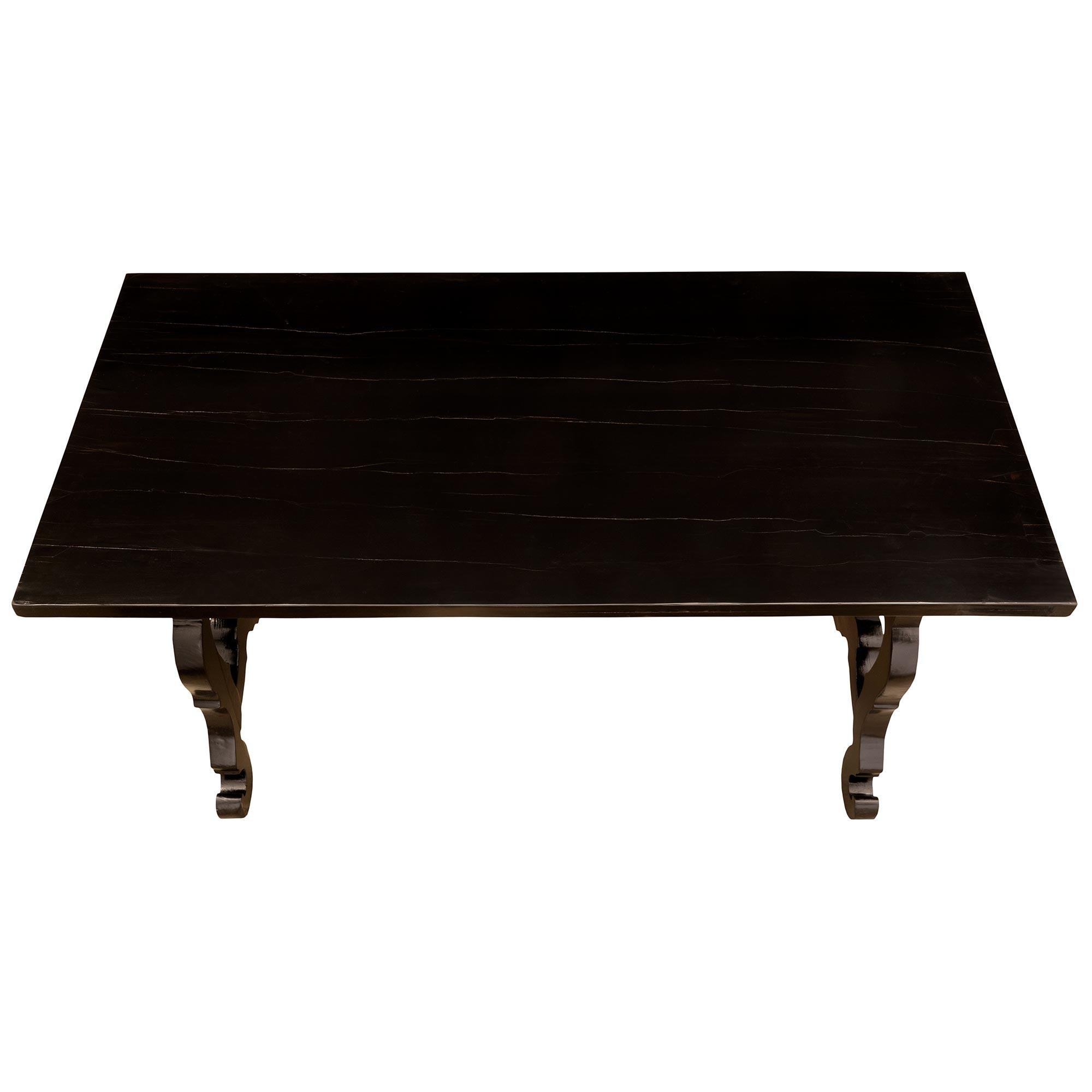 A handsome Italian 18th century ebonized fruitwood trestle table. The table is raised by two sets of scrolled pierced supports connected by the original hand-beaten wrought iron stretcher. Above is the elegant French polish ebonized fruitwood