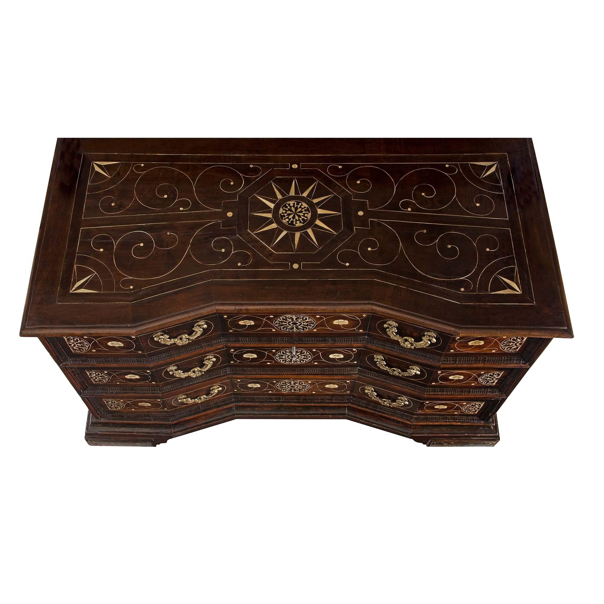 A very handsome and high quality Italian 18th century ebonized fruitwood Milanese commode with very decorative intricate bone inlay throughout. The chest is supported by four large square feet with floral inlay. Each of the angle cut three drawers