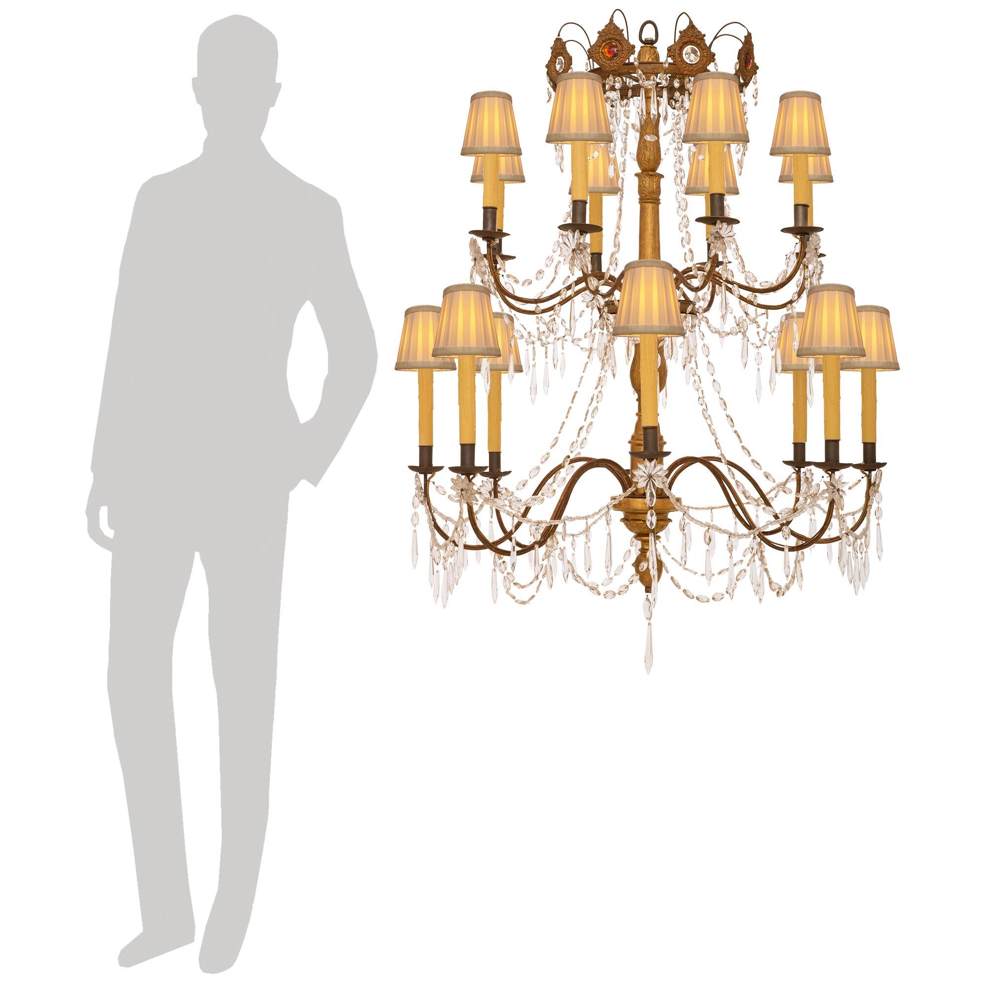 Eine elegante italienische 18. Jahrhundert Genovese st. Giltwood, Eisen und Kristall-Kronleuchter. Diese beeindruckende sechzehn Licht Kronleuchter wird von einem Boden Prisma geschliffen Crystal Anhänger unter dem beeindruckenden und reich