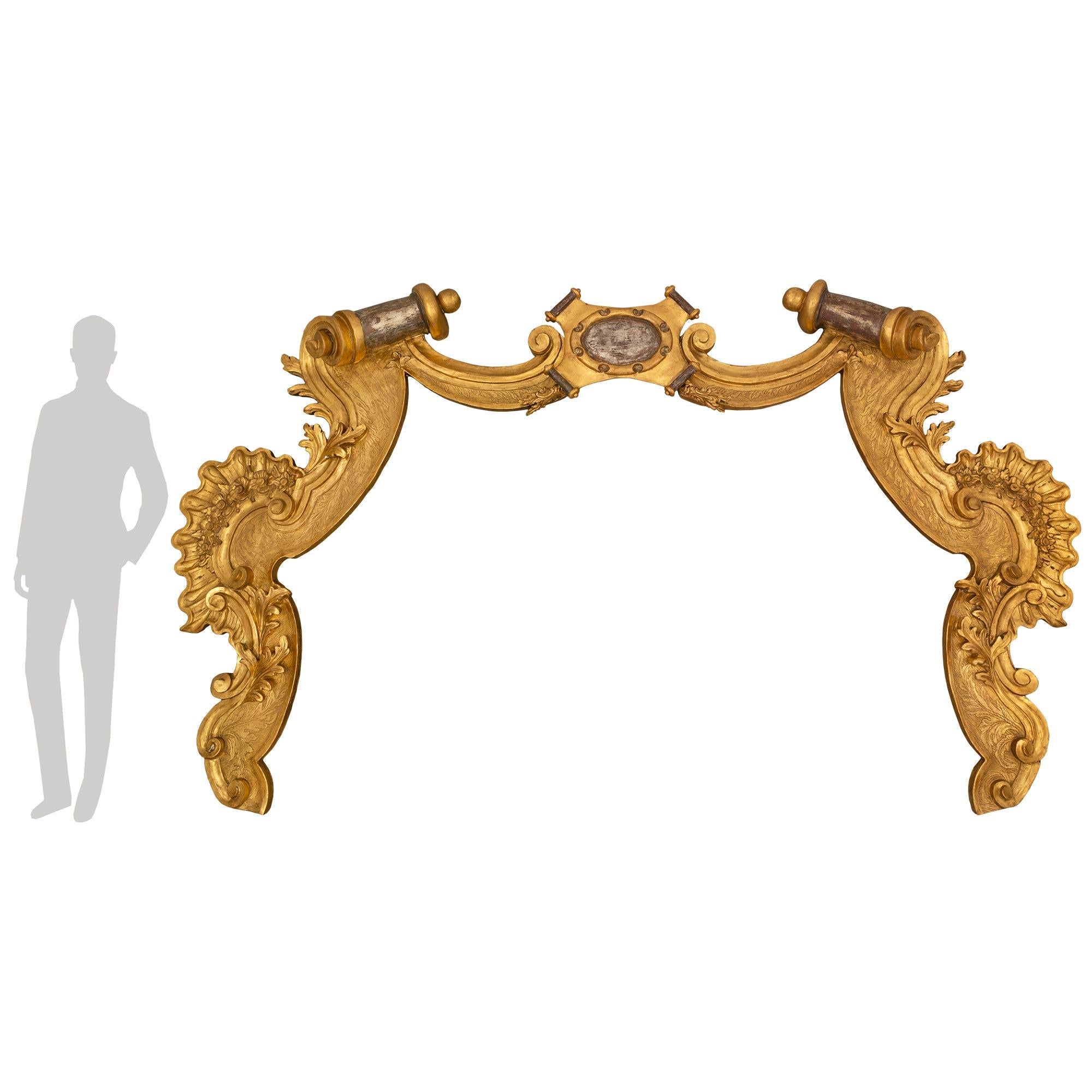 A majestic and large scale Italian 18th century giltwood and mecca architectural element. The unique and extremely decorative carved giltwood element displays beautiful richly carved scrolled foliate designs, charming flowers and finely etched