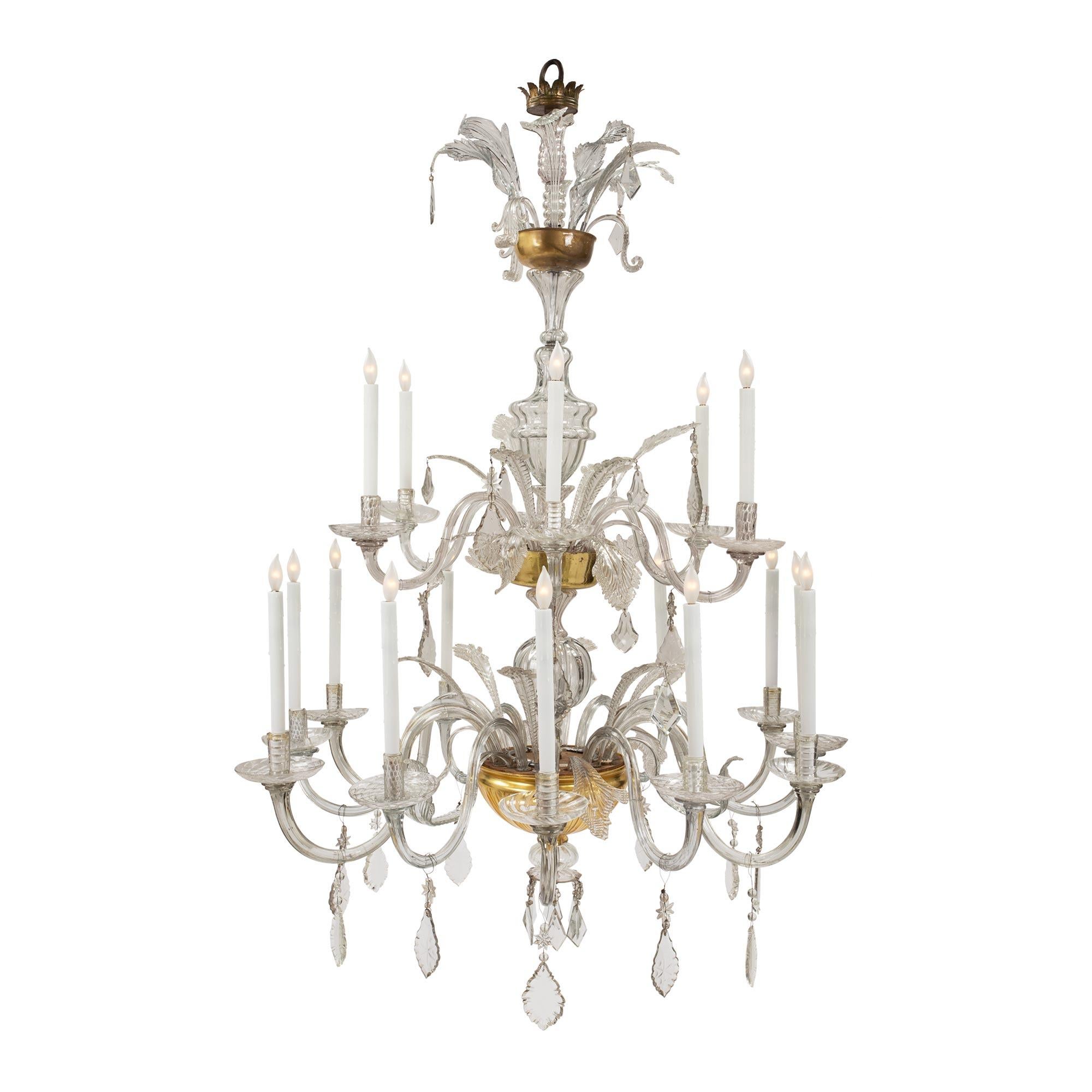 A sensational and large scaled Italian 18th century glass and gilt eighteen light Tuscan chandelier. The chandelier has two levels of light with a most impressive cut glass gilt bowl above a hand blown glass sphere and circular saucer with kite