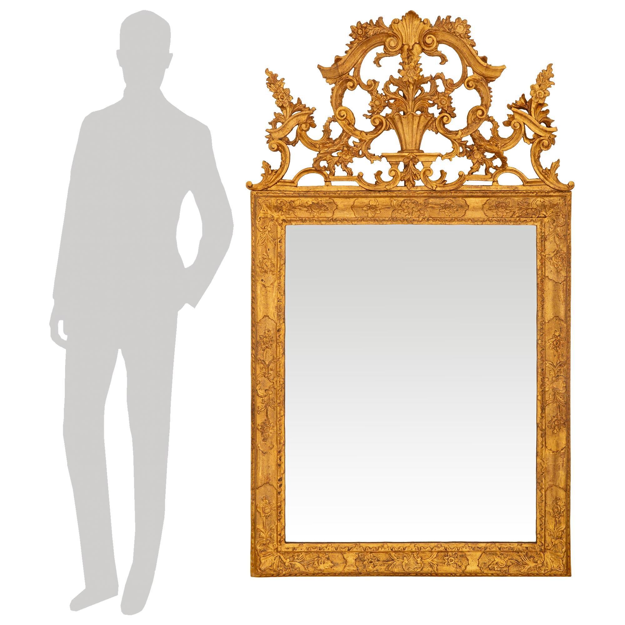 Uno specchio in legno dorato italiano del XVIII secolo, di grande effetto e di alta qualità, del periodo barocco Luigi XIV. Questo meraviglioso specchio con lastra e doratura originale è incorniciato in una cornice rettangolare intagliata e decorata