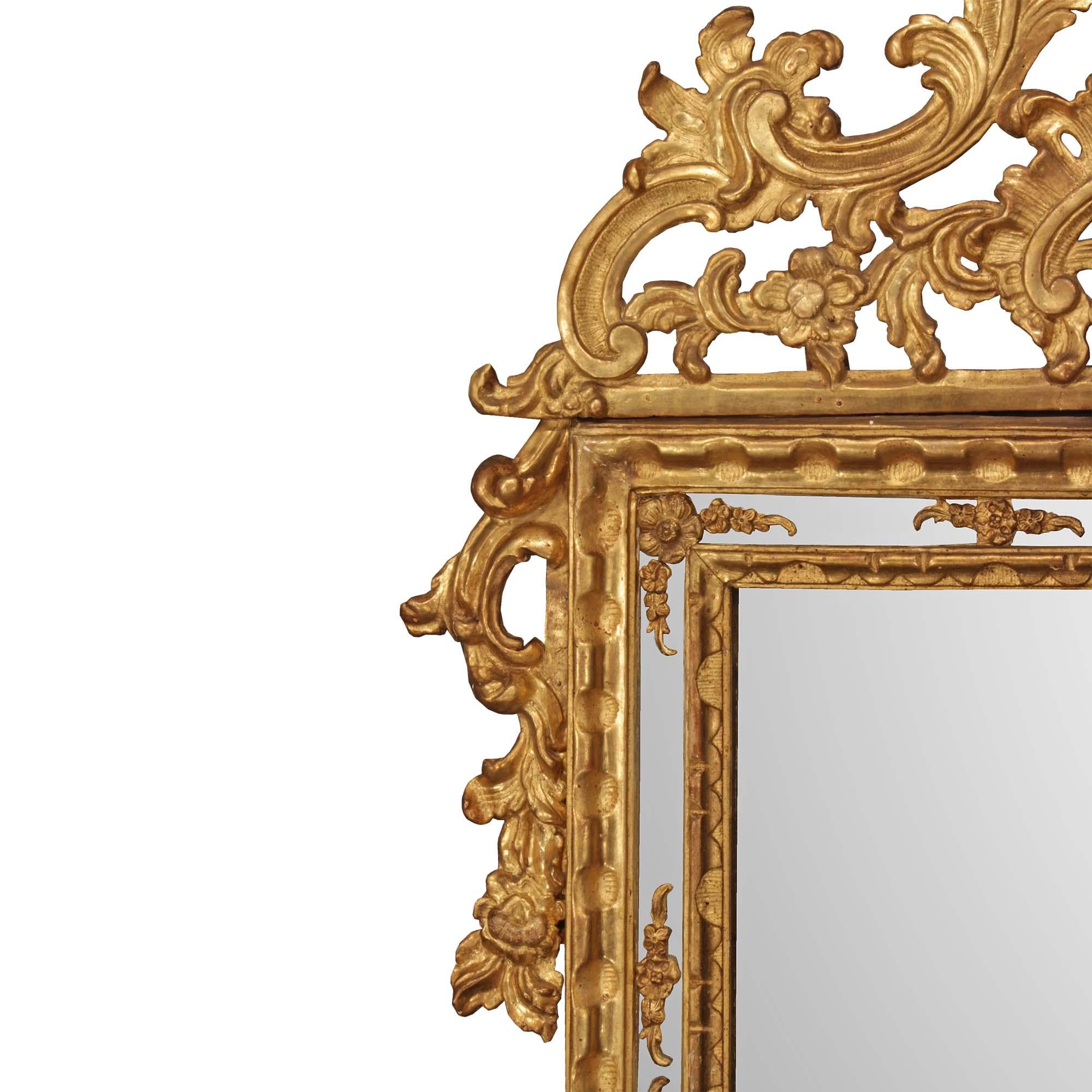 Superbe miroir italien du XVIIIe siècle, d'époque Louis XIV, à double cadre en bois doré. La plaque de miroir originale est encadrée d'un bandeau sculpté dans une finition satinée et brunie et d'une élégante bordure de plaque de miroir avec