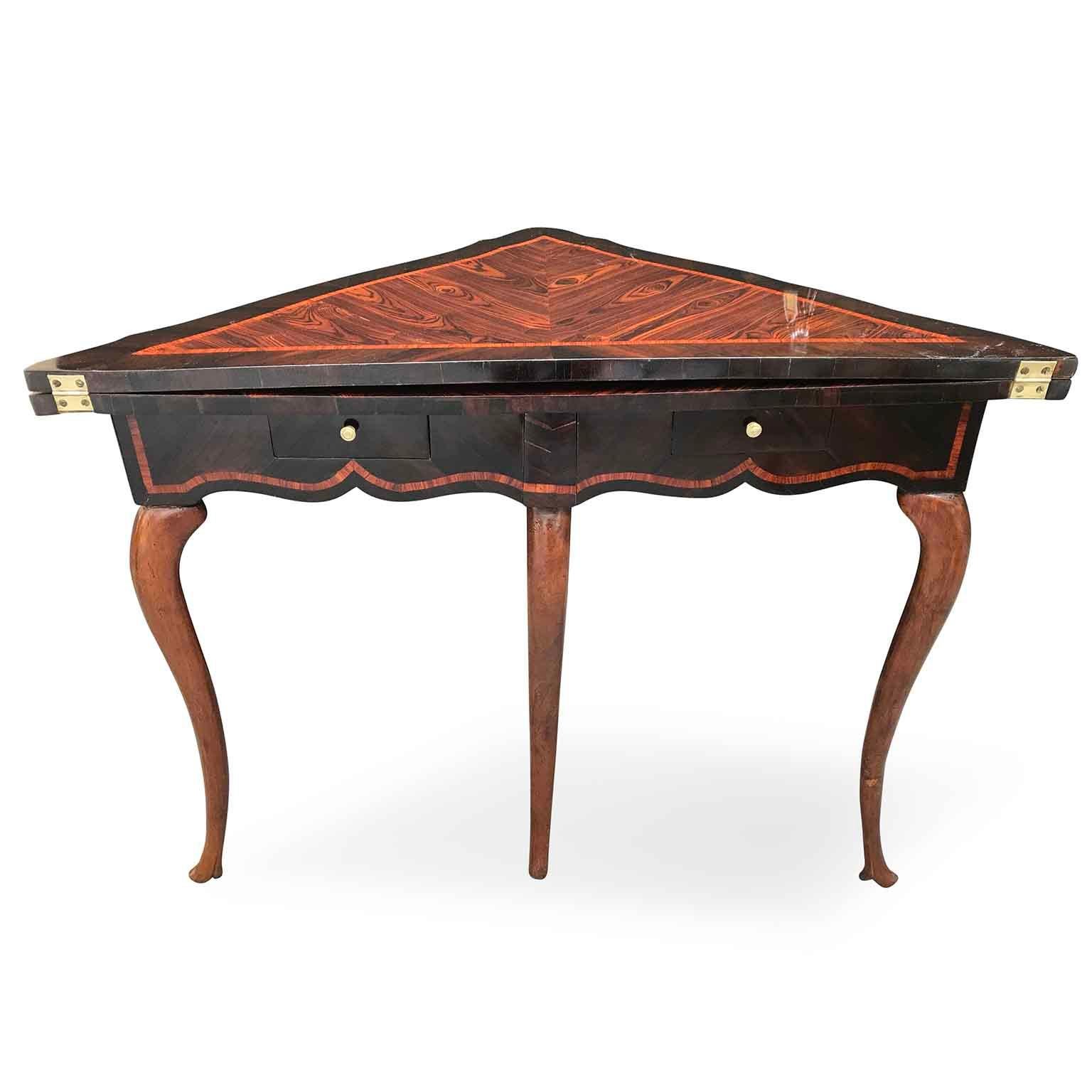 Exclusive Louis XIV Italian Genoese corner card table realized in rosewood and bois de rose, this elegant antique fold over game table dates back to the first half of 18th century. 
Two small drawers on the frontal apron resting on round section à
