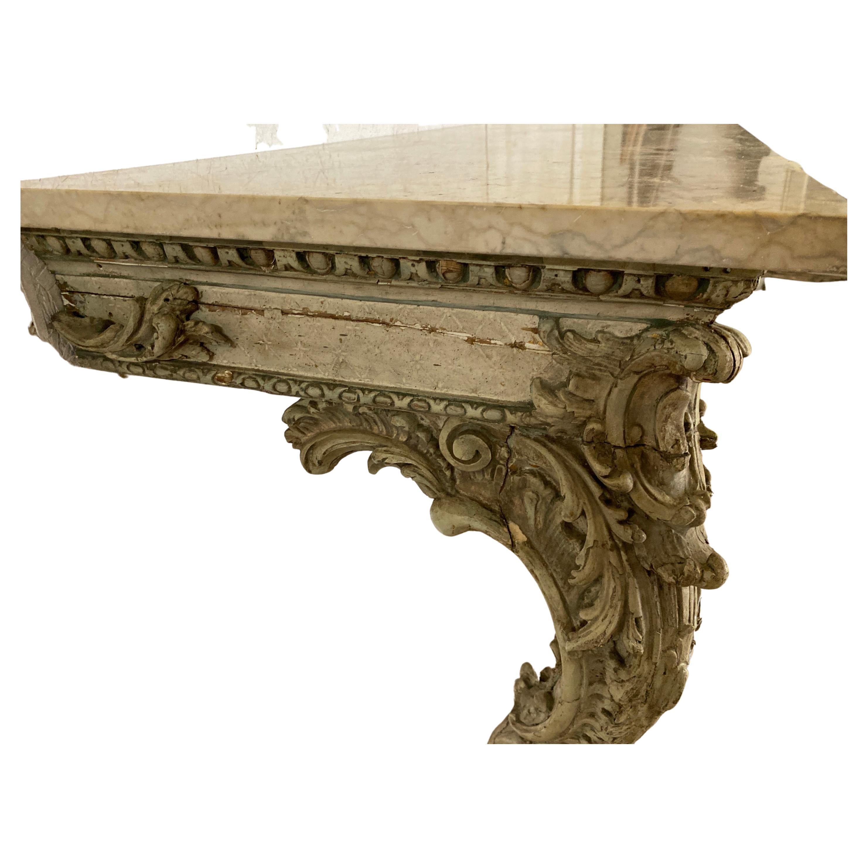 A stunning and extremely decorative Italian 18th century Louis XV period patinated gilt wood and marble console. The wall mounted console is raised by two patinated cabriole legs with carved acanthus leaf accented feet, and larger scrolls at the