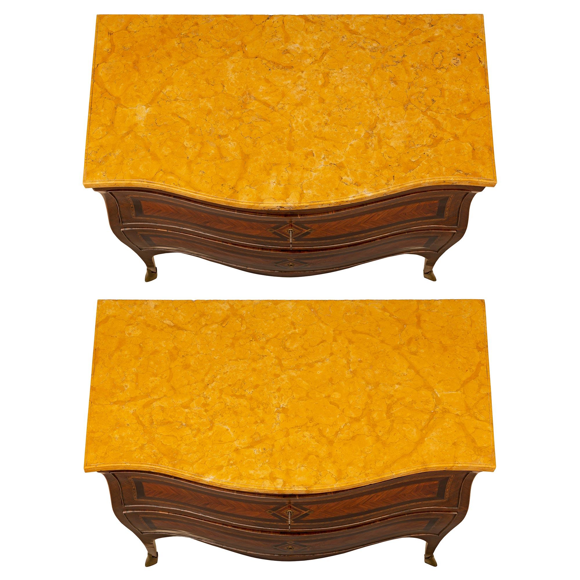 An exquisite and high quality pair of Italian 18th Louis XV period tulipwood and kingwood bombée commodes. Each chest is raised on four cabriole legs with brass wrap around sabots, and elegant tulipwood fillet. Above the arbalest shaped frieze are