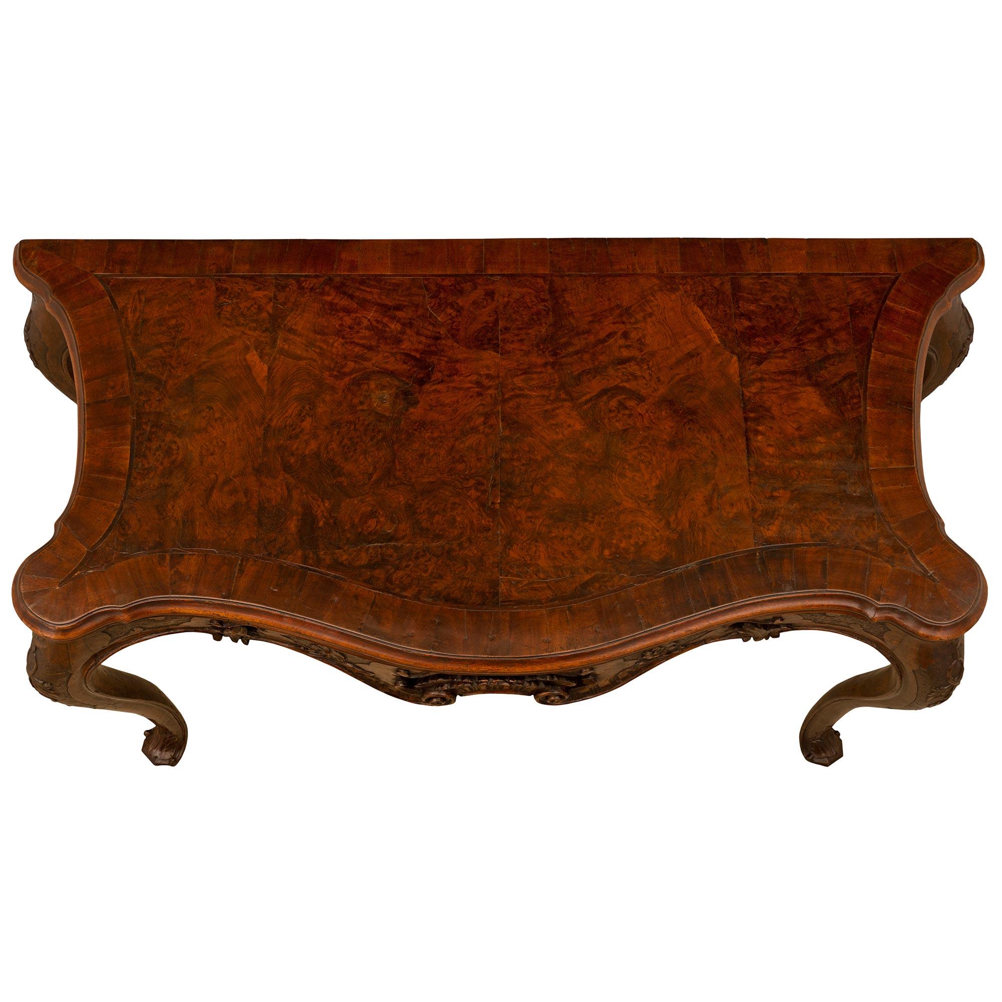 A stunning and extremely decorative Italian 18th century Louis XV period walnut and burl walnut console from Venice. The console is raised by most elegant cabriole legs with beautiful scrolled foliate feet and richly carved interlocking branches and