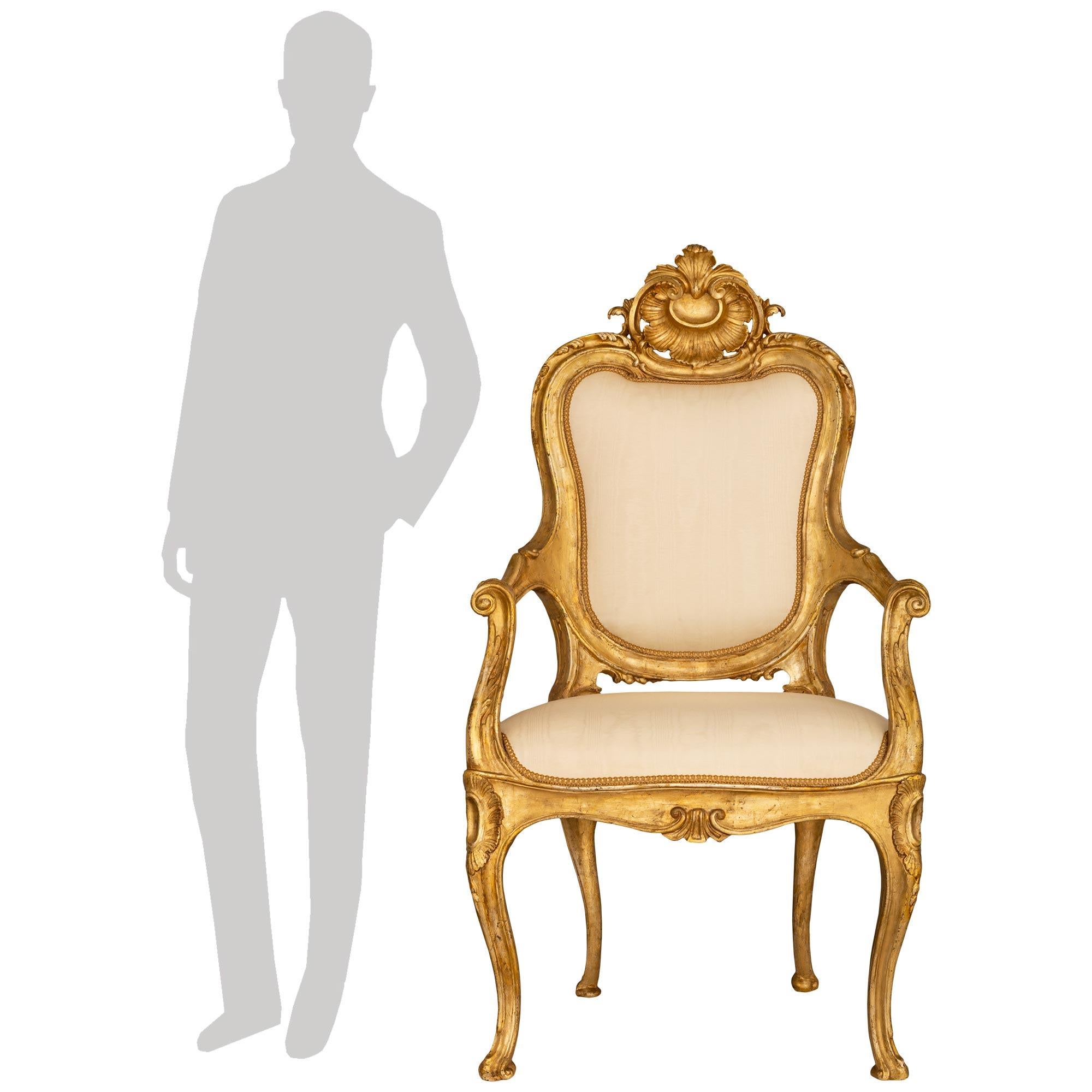 Un superbe et unique fauteuil italien du XVIIIe siècle, de style Louis XV et de style Mecca, provenant de Naples. Cet impressionnant fauteuil trône est surélevé par quatre pieds cabriole avec des pieds à volutes et des sculptures en cabochon sur les